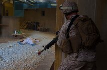 A Marine with 2nd Supply Battalion, Combat Logistics Regiment 25, 2nd Marine Logistics Group looks across a street where his squad was ambushed by simulated enemies during an infantry immersion training course aboard Camp Lejeune, N.C., May 15, 2014. The training put Marines and sailors through possible deployment scenarios, which included attacks during humanitarian assistance operations. 