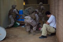 Petty Officer Third Class Kevinjay Flores, a hospital corpsman with 2nd Medical Battalion, 2nd Marine Logistics Group treats simulated Marine and civilian casualties while Marines provide security during an infantry immersion training course aboard Camp Lejeune, N.C., May 15, 2014. Two corpsmen from 2nd Medical Battalion joined Marines with 2nd Supply Battalion, Combat Logistics Regiment 25, 2nd MLG to train for combat and humanitarian assistance missions.
