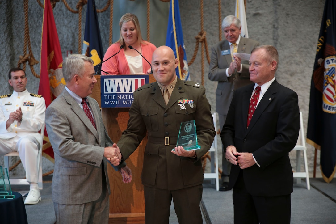 Retired Marine Maj. Gen. David Mize (left), president of the Mayor’s Military Advisory Committee, and retired Marine Lt. Col. Jerry Sneed (right), deputy mayor of Homeland Security for the City of New Orleans, present Capt. Samuel Baumer (center), the adjutant for 4th Marine Logistics Group, the Mayor’s Community Service Award at the National World War II Museum, May 17, 2014. Baumer was nominated for the award for his significant contribution to improving the local community in and around New Orleans. In 2013, Baumer supervised 310 Marines during 2,009 hours of community service for more than 40 different events. 