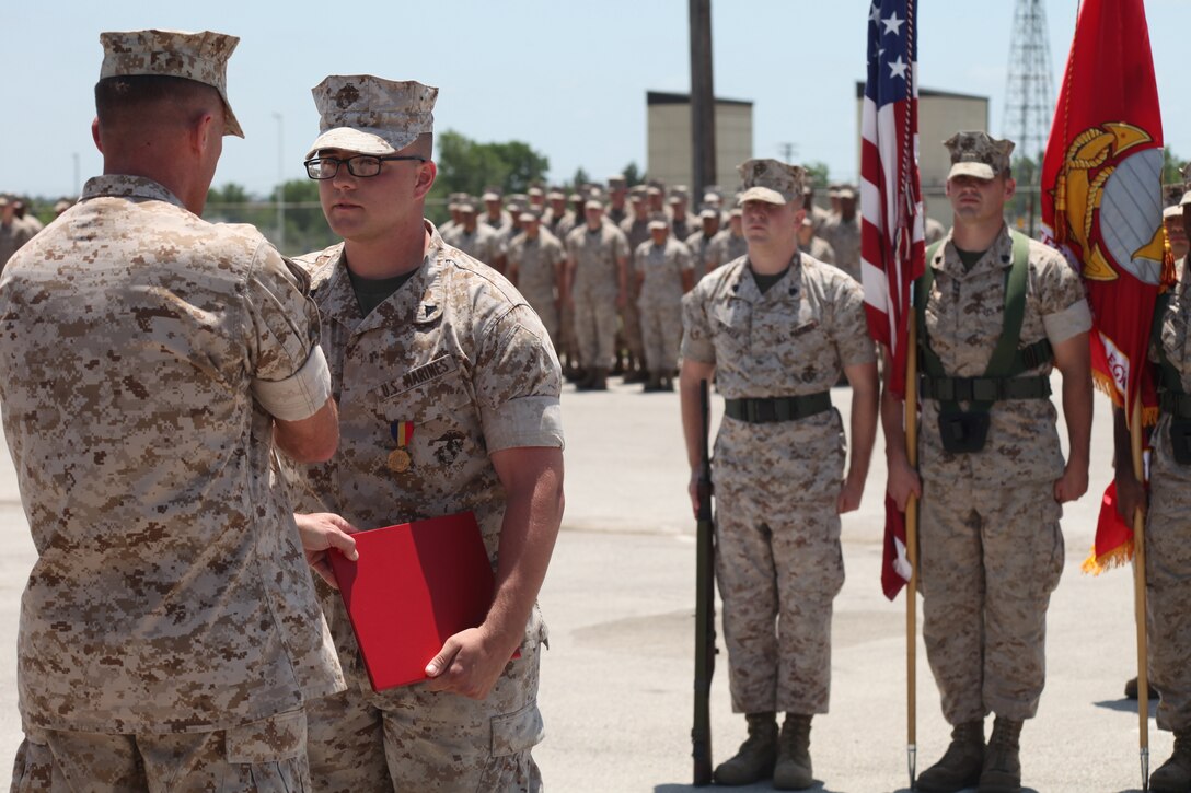 Col. Michael Gann, commanding officer, 14th Marine Regiment, presents Lance Cpl. Bryan Daniels of Keller, Texas, with the Navy and Marine Corps Medal in an official ceremony May 18, 2014. Daniels is a reserve motor transport operator at Headquarters Battery, 14th Marine Regiment. The Navy and Marine Corps Medal is the highest non-combat decoration awarded for heroism by the United States Department of the Navy to the members of the United States Navy and United States Marine Corps.(Official Marine Corps Photo by Staff Sgt. Joel Chaverri)