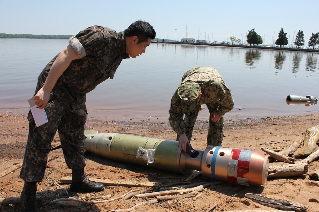 A U.S. Navy Explosive Ordnance Disposal technician and a South Korean military member measure a simulated water-borne IED for identification on the Potomac River shore in The Town of Quantico on May 14, during the Defense Intelligence Agency’s weeklong Joint Captured Materiel Exploitation Center exercise, hosted by Marine Corps Intelligence Activity aboard Marine Corps Base Quantico from May 12 to 16. 