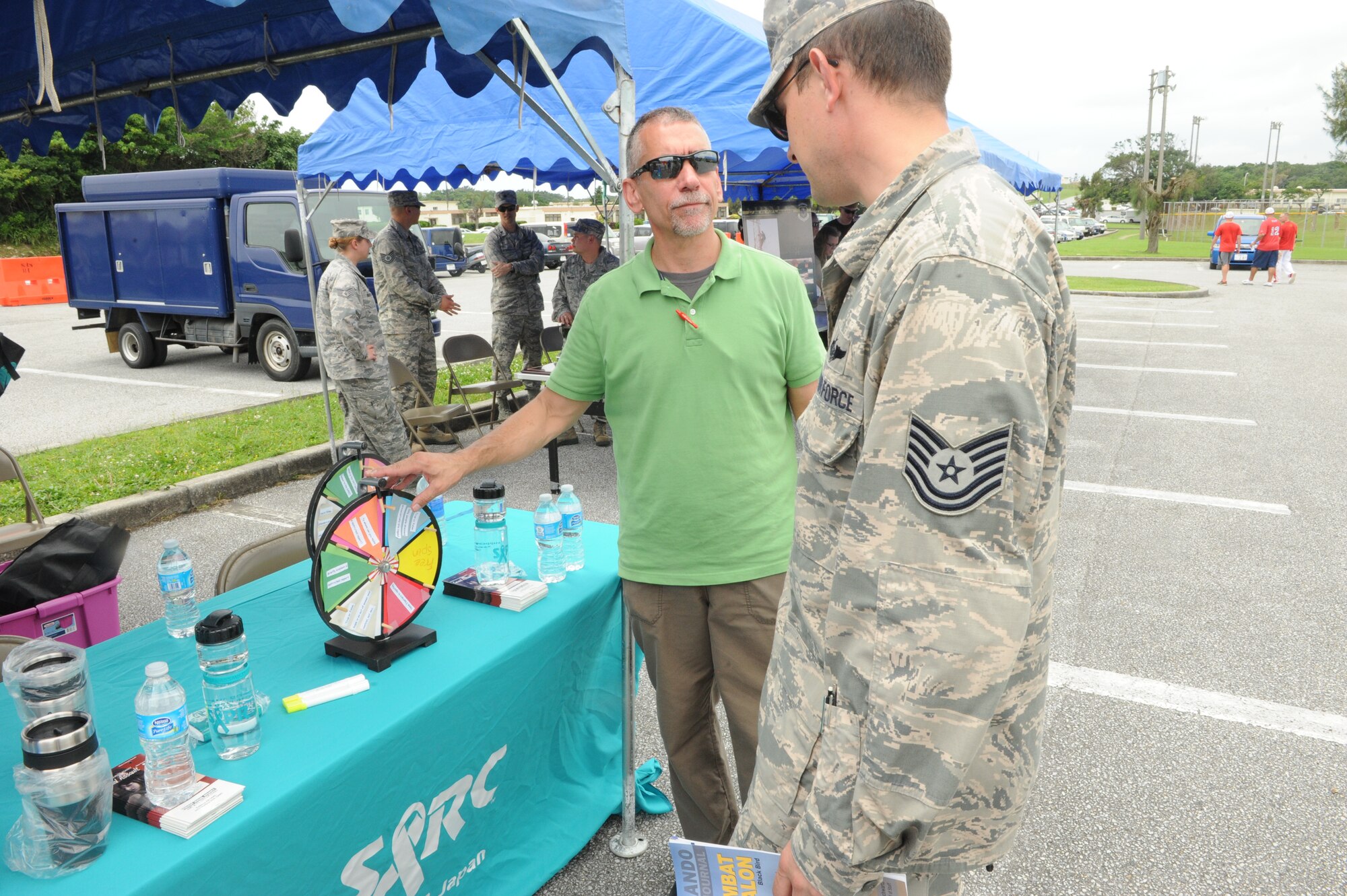 Joseph Miller, Sexual Assault Prevention and Response program manager, spins a wheel for questions to ask military members to win prizes on Kadena Air Base, Japan, May 19, 2014. Airmen answered questions to test their knowledge of sexual assault in the military during the safety fair for Safety and Wingmanship Day. (U.S. Air Force photo by Airman 1st Class Stephen G. Eigel)