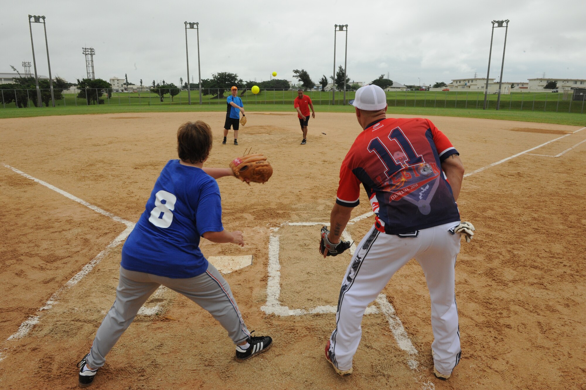 U.S. Air Force Col. Brian McDaniel, 18th Wing vice commander, and Chief Master Sgt. David Brown, Erwin Professional Military Education center commandant, toss the first pitches during the Stars Versus Stripes softball game on Kadena Air Base, Japan, May 19, 2014. McDaniel and Brown were the captains for the Stars Versus Stripes game, which is planned to be held annually. (U.S. Air Force photo by Airman 1st Class Stephen G. Eigel) 