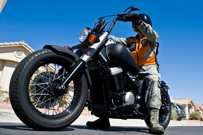 Tech. Sgt. Kevin Garces, 99th Air Base Wing executive assistant to the command chief, demonstrates the proper motorcycle safety gear for military members to wear while riding May 20, 2014, at Nellis Air Force Base, Nev. The Critical Days of Summer are approaching and motorcycle safety is an issue, when riding always wear long pants, long sleeves, boots, gloves, and a Department of Transportation approved helmet. Reflective vests are also required when riding in conditions that result in low visibility. There were 36 motorcycle fatalities from June 2009 until September 2013. (U.S. Air Force photo by Senior Airman Christopher Tam)