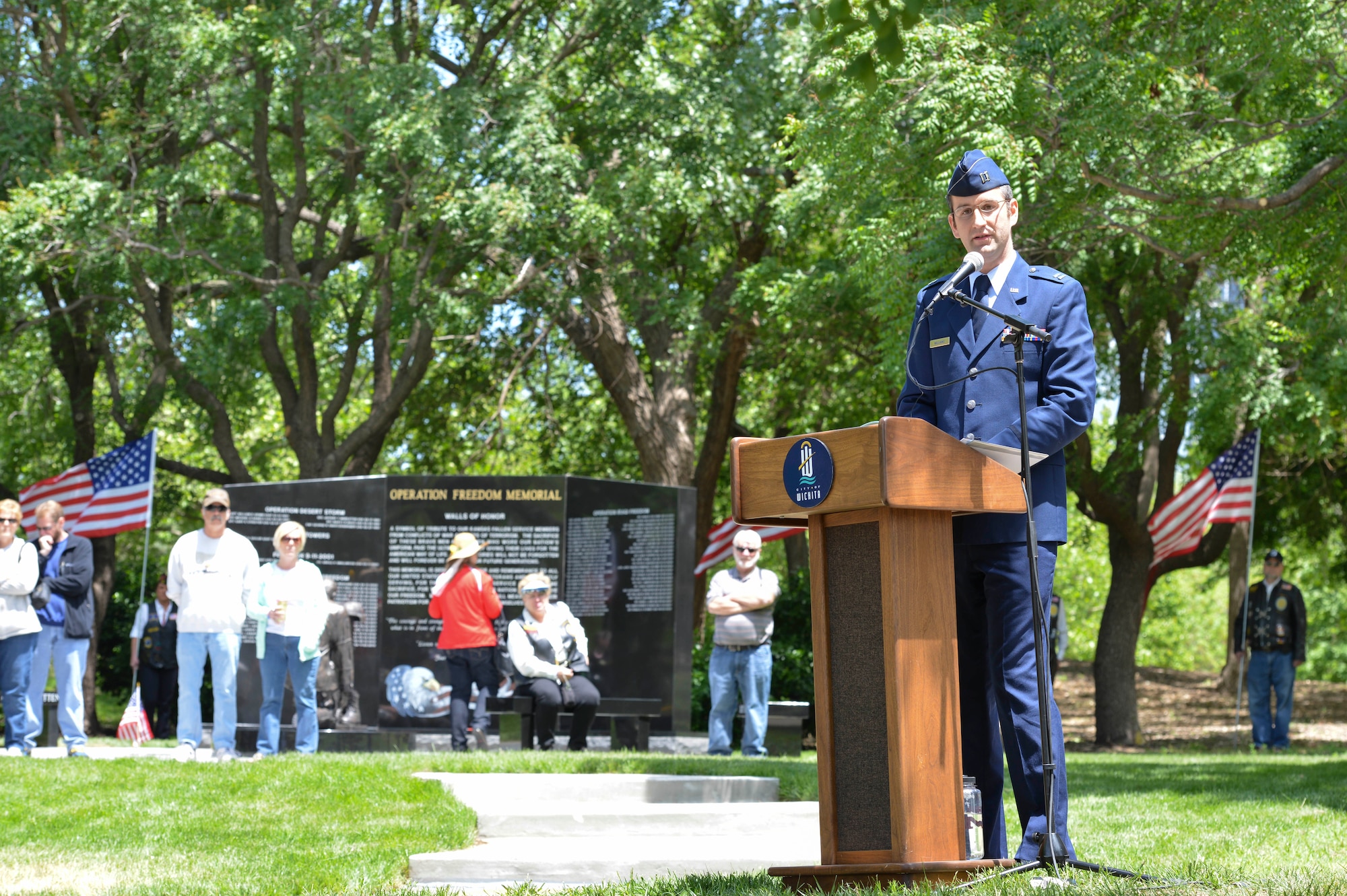Capt. Nick Williams, 9th Airlift Squadron C-5 Galaxy pilot, Dover Air Force Base, Delaware, addresses audience members attending the new Operation Freedom Memorial, during a dedication ceremony, May, 17, 2014, in Wichita, Kansas. Formerly stationed at McConnell Air Force Base, Kansas, Williams was among the board of committee members for OFM’s foundation and helped raise money for the project through donations. (U.S. Air Force photo/Staff Sgt. Jess Lockoski)