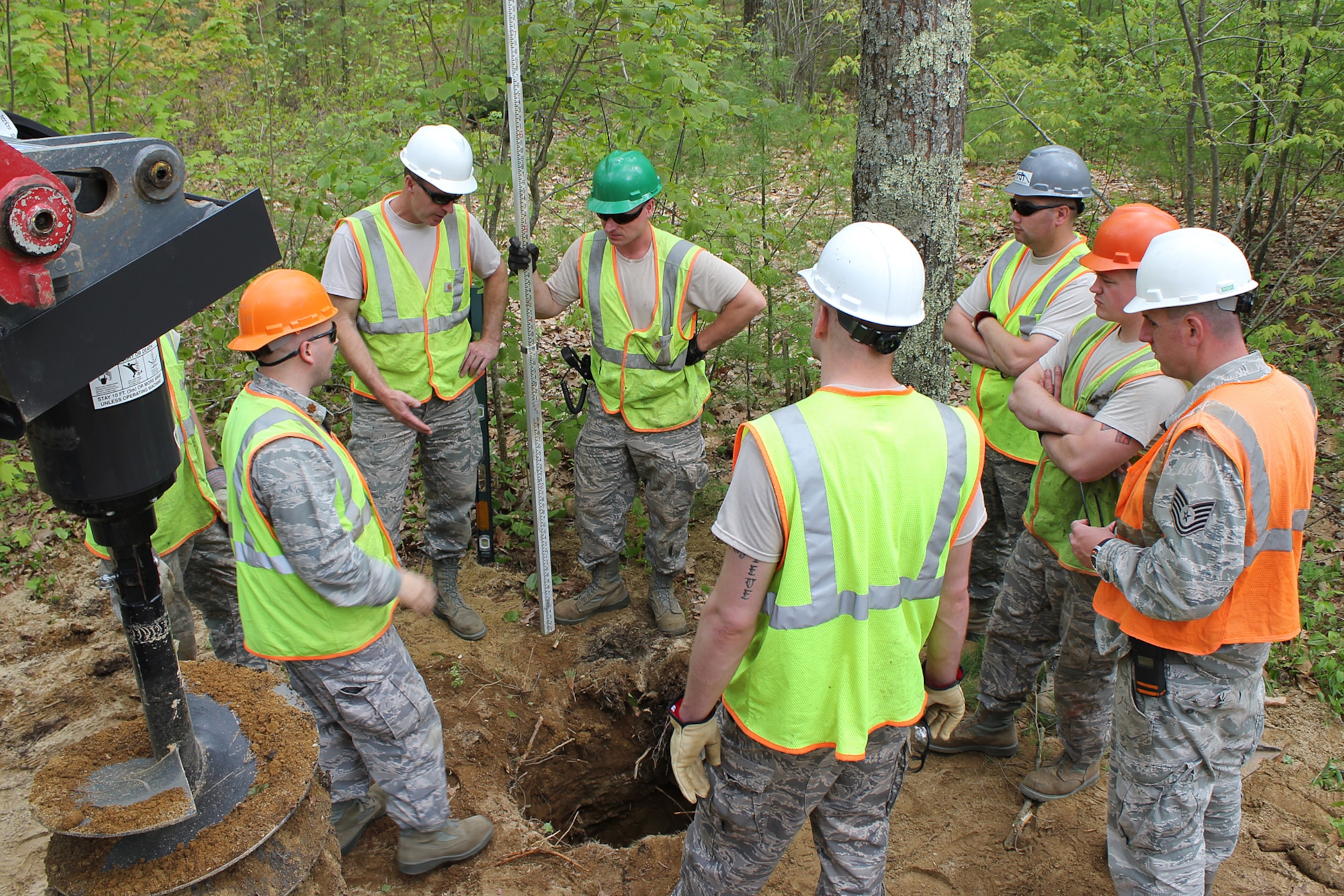 140520-Z-VA676-032 – Airmen from the 127th Civil Engineer Squadron, Selfridge Air National Guard Base, Mich., have a quick planning session while preparing a foundation for a new cabin at Camp Hind Boy Scout Camp, Raymond, Maine, May 20, 2014. The Airmen, along with Marine Corps Reservists and Army Reservists, are working on various construction projects at the camp during an Innovative Readiness Training mission, which allows military personnel to get training in various tasks and a community organization, in this case the Boy Scouts, to benefit from the work. (U.S. Air National Guard photo by Technical Sgt. Dan Heaton)