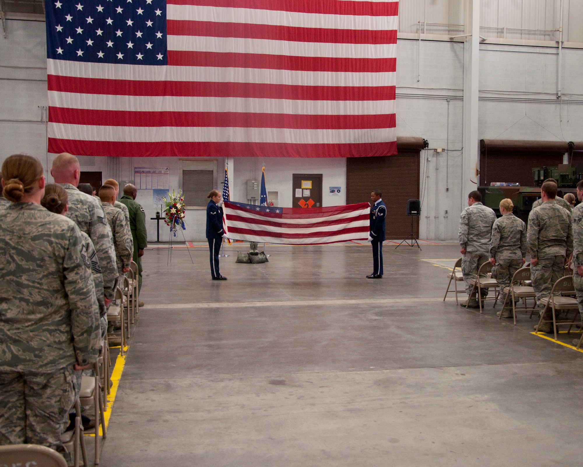 140516-F-BR137-005
The crowd stands at attention during the flag-folding portion of a retreat ceremony in the Peacekeeper High Bay May 16, 2014. (U.S. Air Force photo by Airman 1st Class Jason Wiese)
