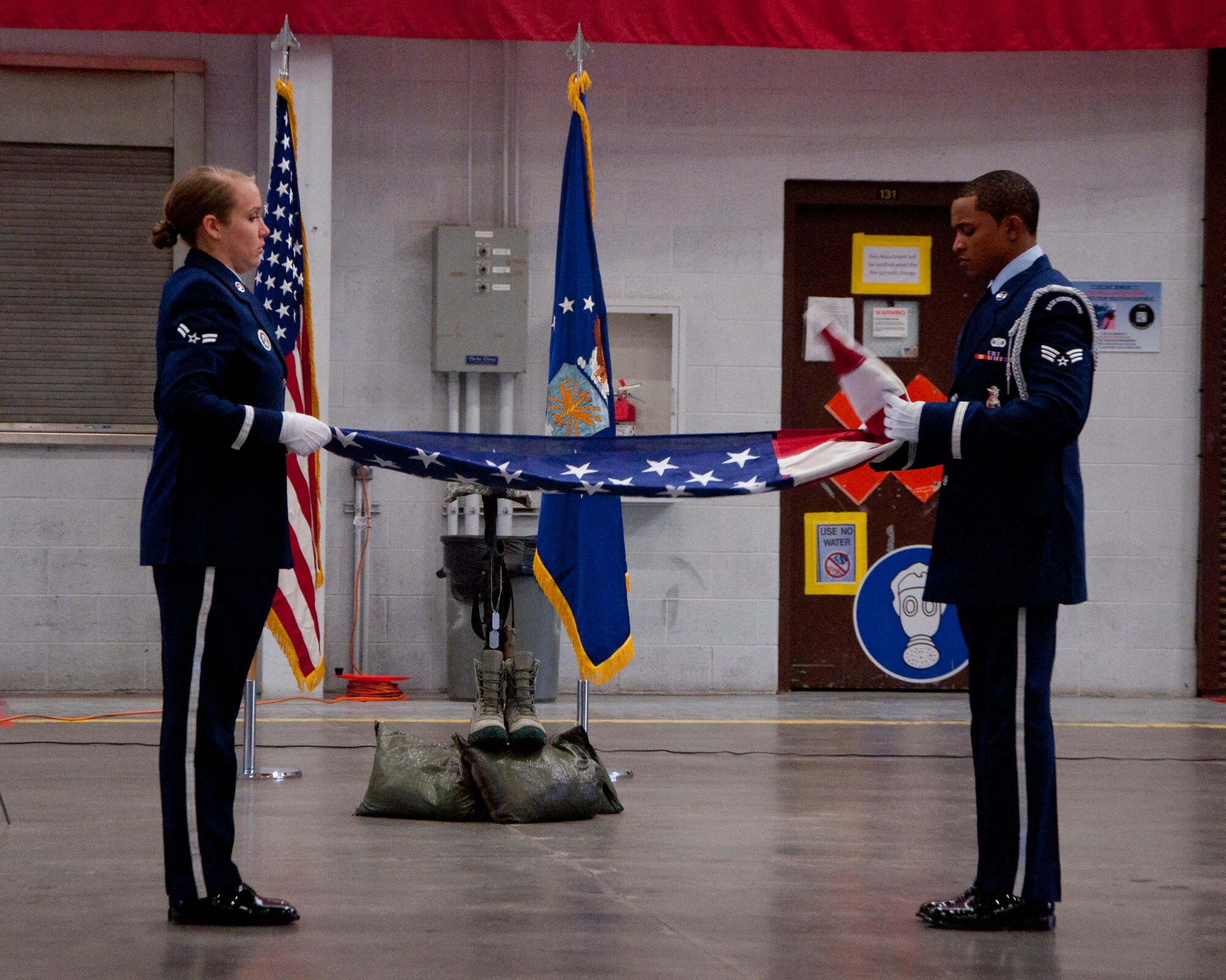 140516-F-BR137-004
Ceremonial guardsmen, Airman 1st Class Rena Bissett and Senior Airman Duane Funderburk, fold a U.S. flag during a retreat ceremony in the Peacekeeper High Bay May 16, 2014. (U.S. Air Force photo by Airman 1st Class Jason Wiese)
