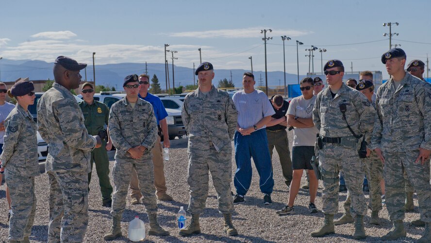 49th Security Forces Squadron members gather around to listen to Capt. Schneider Rislin, 49th SFS commander, give opening remarks on the first day of National Police Week with some words from the heart at Holloman Air Force Base, N.M., May 12.  According to the National Police Week website, President John F.  Kennedy signed a proclamation in 1962 that designated May 15 as Peace Officers Memorial Day and the week in which that date falls as National Police Week.  Since the inception of National Police Week, the United States Air Force has lost 120 military and civilian law enforcement officers. (U.S. Air Force photo by Staff Sgt. E’Lysia Wray/Released)