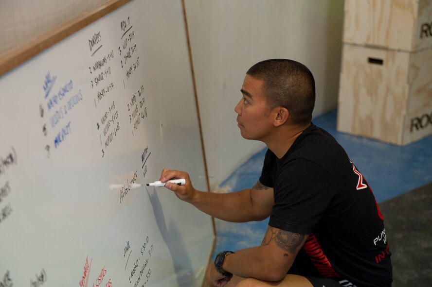 Major Gabe Avilla, 49th Communications Squadron commander and a certified CrossFit instructor, updates a board listing the times and scores of the competitors of the Fittest Wingmen Throwdown 2 at Holloman Air Force Base, N.M., May 16. The Fittest Wingmen Throwdown competition rated Airmen’s performance across various CrossFit exercises to ultimately decide a winning team of more than 20 participants. (U.S. Air Force photo by Airman 1st Class Aaron Montoya / Released)
