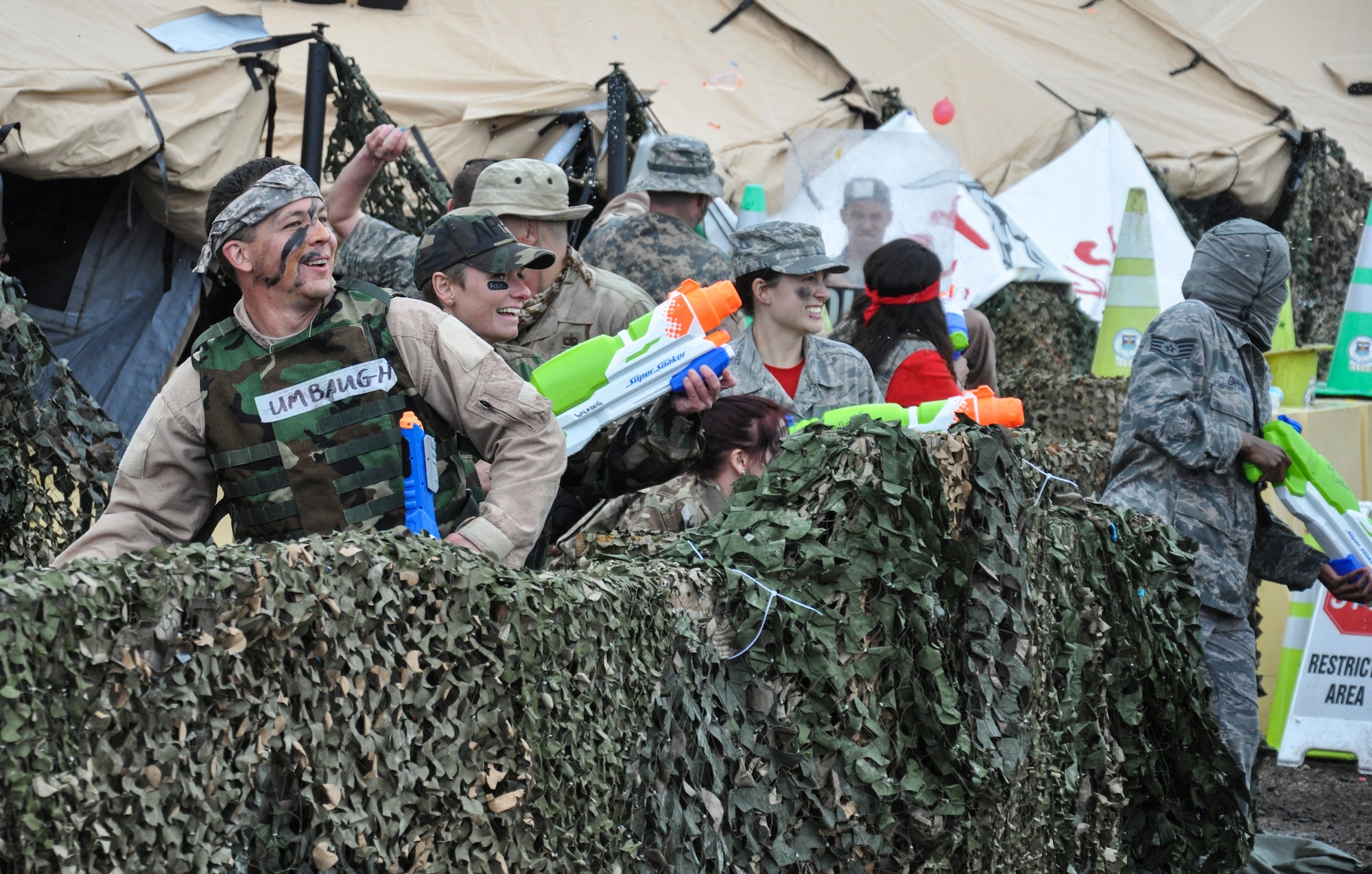 Team Buckley members hurl water balloons and fire water guns at each other during the Combat Dining Out festivities May 16, 2014, at Camp Rattlesnake on Buckley Air Force Base, Colo. The dining out brought all members of the base together for water battles, an obstacle course, camaraderie and some good, clean fun. (U.S. Air Force photo by Staff Sgt. Nicholas Rau/Released)
