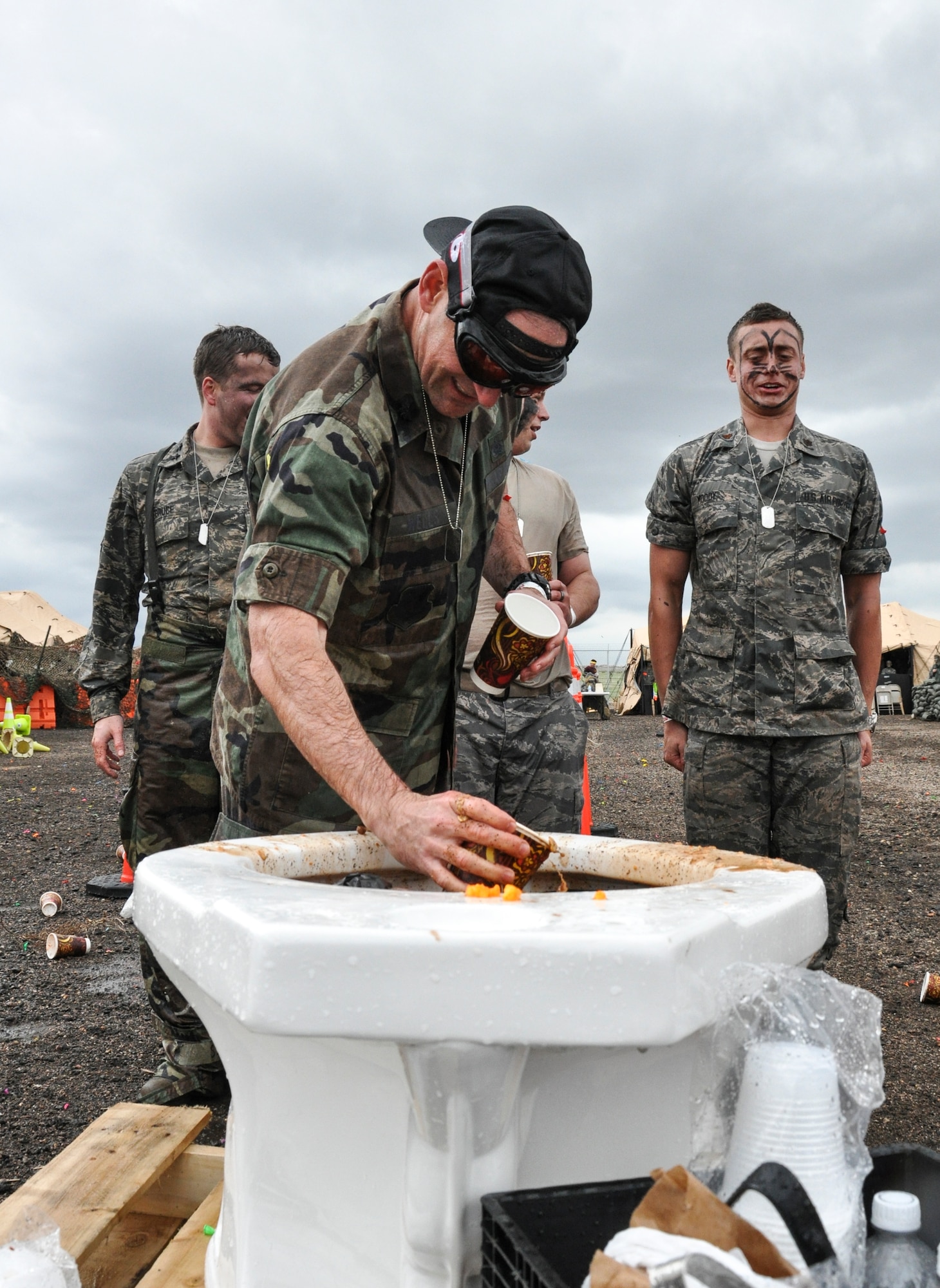 Lt. Col. Hew Wells, 460th Space Communications Squadron commander, prepares a cup from the grog bowl for his Airmen during the Combat Dining Out festivities May 16, 2014, at Camp Rattlesnake on Buckley Air Force Base, Colo. The dining out brought all members of the base together for water battles, an obstacle course, camaraderie and some good, clean fun. (U.S. Air Force photo by Staff Sgt. Nicholas Rau/Released) 