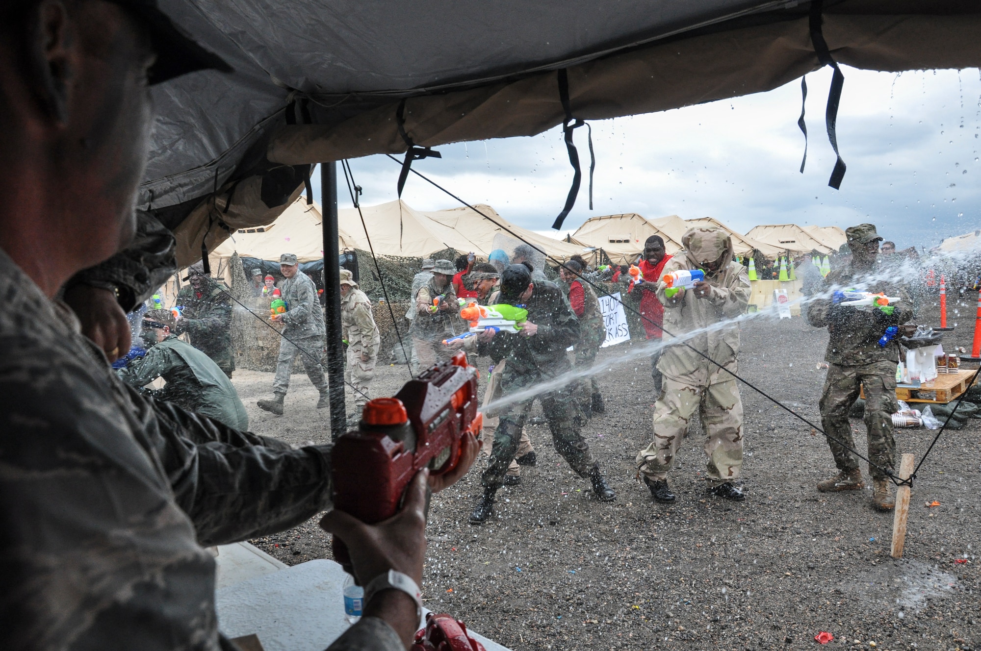 Col. Mitch Stratton, 460th Space Wing vice commander, and the head table fend off a water assault from Team Buckley during the Combat Dining Out festivities May 16, 2014, at Camp Rattlesnake on Buckley Air Force Base, Colo. The dining out brought all members of the base together for water battles, an obstacle course, camaraderie and some good, clean fun. (U.S. Air Force photo by Staff Sgt. Nicholas Rau/Released) 
