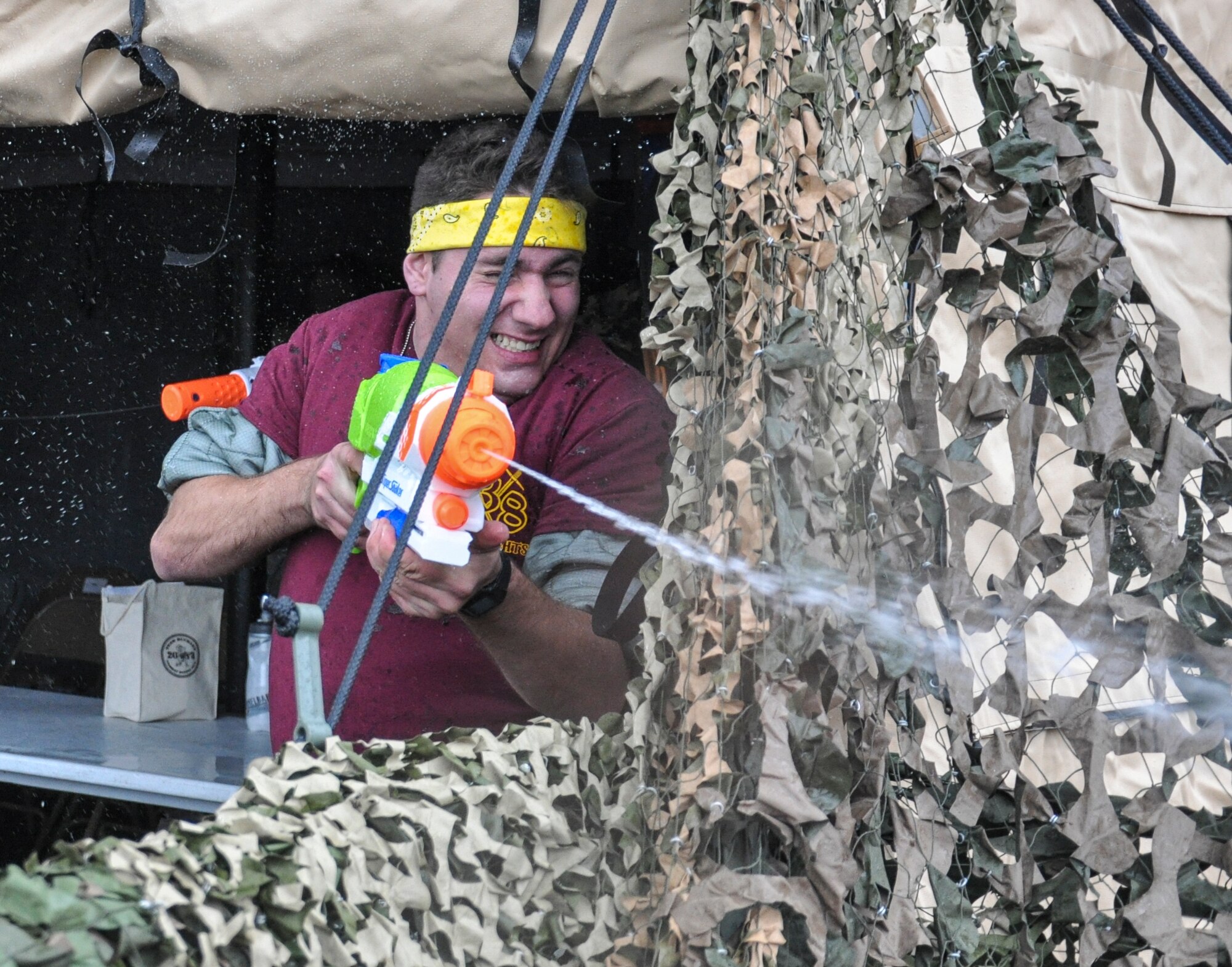 Airman 1st Class James Ramroth, 460th Operations Group satellite technician, fires at other team members during the Combat Dining Out festivities May 16, 2014, at Camp Rattlesnake on Buckley Air Force Base, Colo. The dining out brought all members of the base together for water battles, an obstacle course, camaraderie and some good, clean fun. (U.S. Air Force photo by Staff Sgt. Nicholas Rau/Released) 