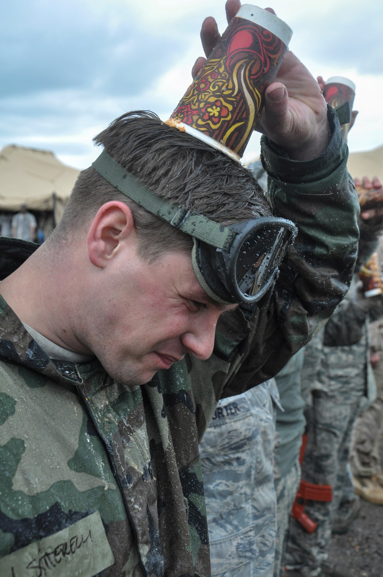 Senior Airman Nathan Satterelli, 460th Space Wing command chief’s executive assistant, grimaces after finishing his cup of grog during the Combat Dining Out festivities May 16, 2014, at Camp Rattlesnake on Buckley Air Force Base, Colo. The dining out brought all members of the base together for water battles, an obstacle course, camaraderie and some good, clean fun. (U.S. Air Force photo by Staff Sgt. Nicholas Rau/Released) 