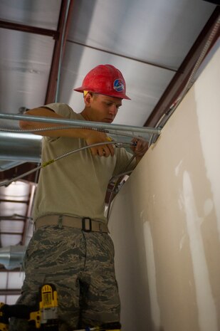 Airman 1st Class Kile Wagener, 820th RED HORSE electrical systems apprentice, works on electrical wires May 15 at Nellis Air Force Base. RED HORSE has been designing and building the new housing area fire station since 2012. (U.S. Air Force photo by Airman 1st Class Jake Carter)