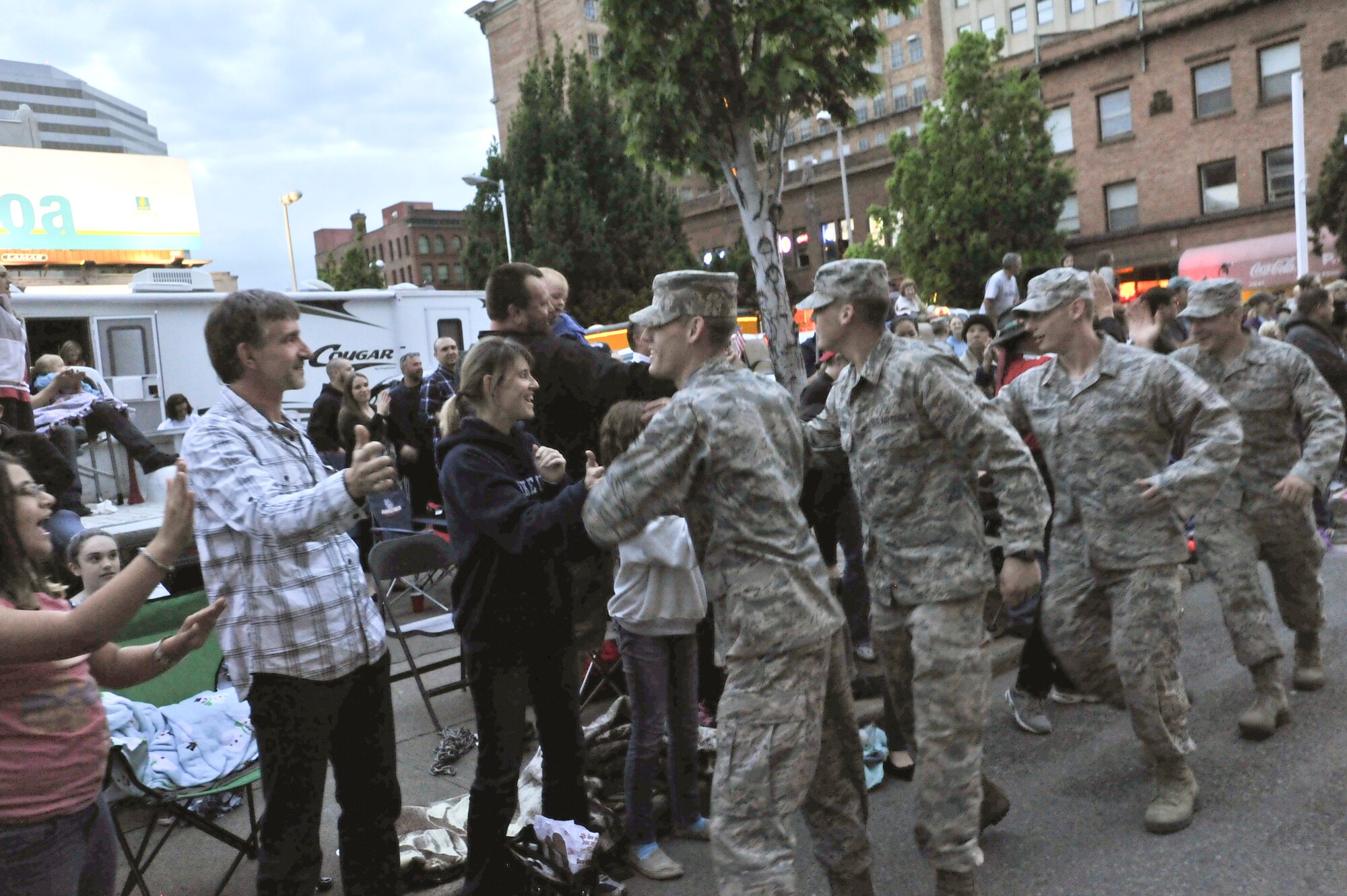 Members for team Fairchild shake hands with the crowd during the Lilac Festival 2014 Armed Forced Torchlight Parade in Spokane Wash., May 17, 2014. The parade is the largest armed forces torchlight parade in the nation.  (U.S. Air Force photo by Staff Sgt. Veronica Montes/Released)