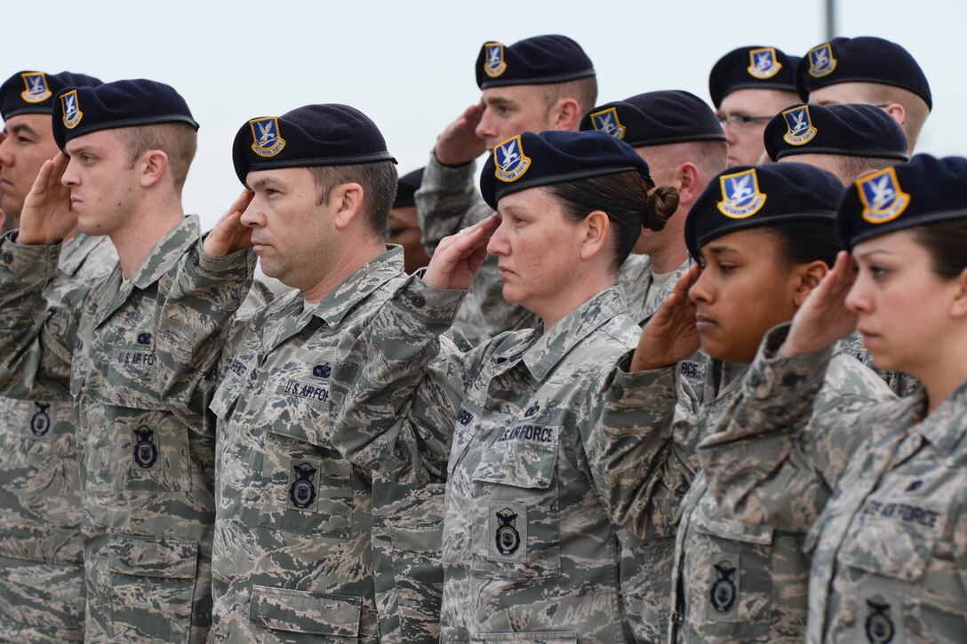 Airmen of the 28th Security Forces Squadron render salutes as the flag is lowered during a Police Week retreat ceremony on Ellsworth Air Force Base, S.D., May 15, 2014. For more than 47 years National Police Week has been a time dedicated to honor local, state and federal law enforcement members currently serving as well as remembering fallen officers. (U.S. Air Force photo by Senior Airman Zachary Hada/Released)
