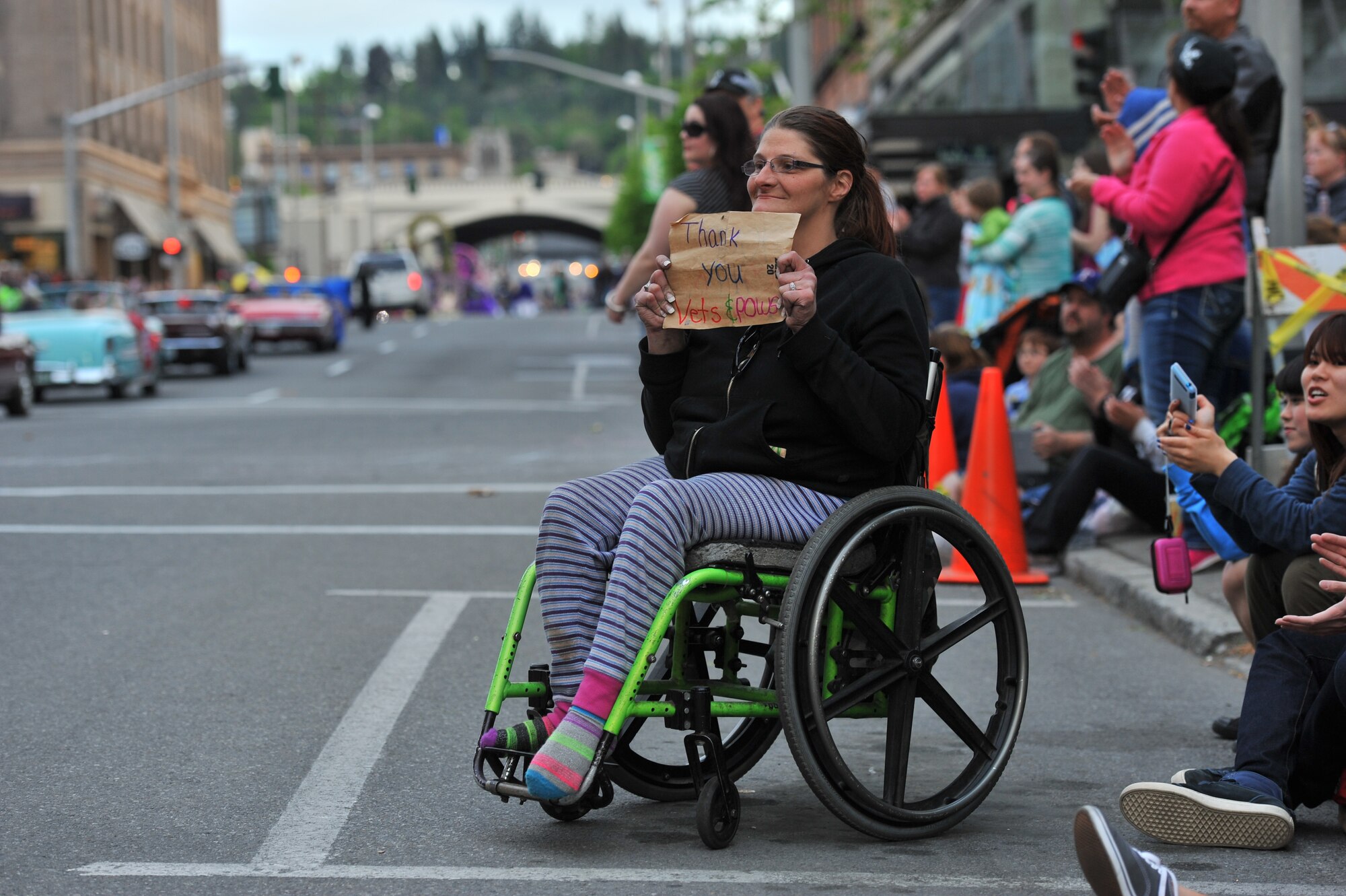 April Belnap holds up a sign for the war veterans and prisoners of war as the drive by during the Lilac Festival 2014 Armed Forced Torchlight Parade in Spokane Wash., May 17, 2014. This parade is the largest armed forces torchlight parade in the nation. (U.S. Air Force photo by Staff Sgt. Veronica Montes/Released) 