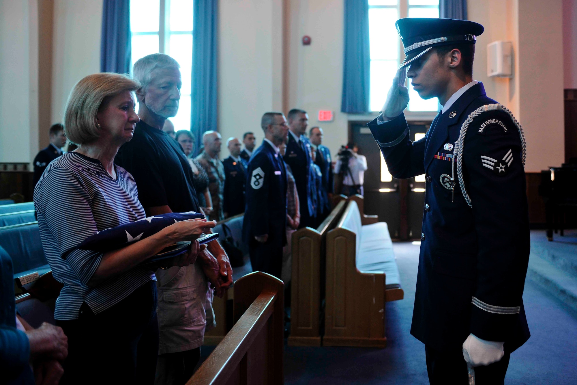 ALTUS AIR FORCE BASE, Okla. – U.S. Air Force Senior Airman Franklin Ramos, 97th Air Mobility Wing Honor Guard member salutes Deborah Adair, mother of U.S. Air Force Staff Sgt. Tedd Adair at the base chapel May 19, 2014. More than 150 Airmen and their families filled the base chapel in remembrance of Tedd Adair, who passed away May 10 after being diagnosed with Cancer. He is survived by his father Jack, mother Deborah, brother Todd, sister Kerri, son Wyatt and daughter Trinity. (U.S. Air Force photo by Senior Airman Jesse Lopez/Released)