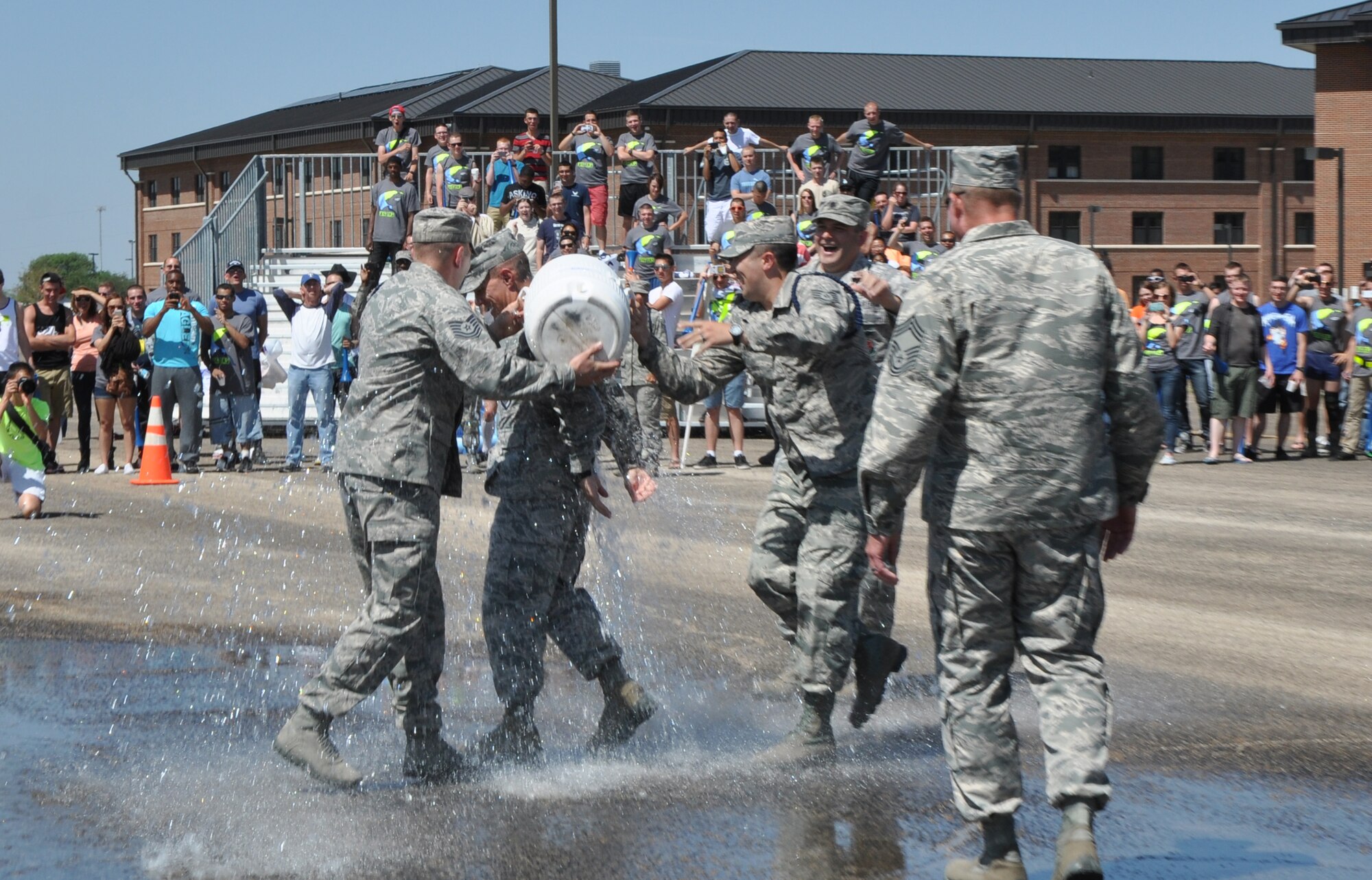 GOODFELLOW AIR FORCE BASE, Texas – Members from the 17th Training Group pour a bucket of water on Col. Brendan M. Harris, 17th TRG Commander, at the 17th TRG’s second quarter drill competition on the flight line here May 10. Lt. Col. Derek R. Ferland, 312th Training Squadron Commander, originally made Harris believe he would be sprayed with a fire hose. (U.S. Air Force photo/ Senior Airman Joshua Edwards)