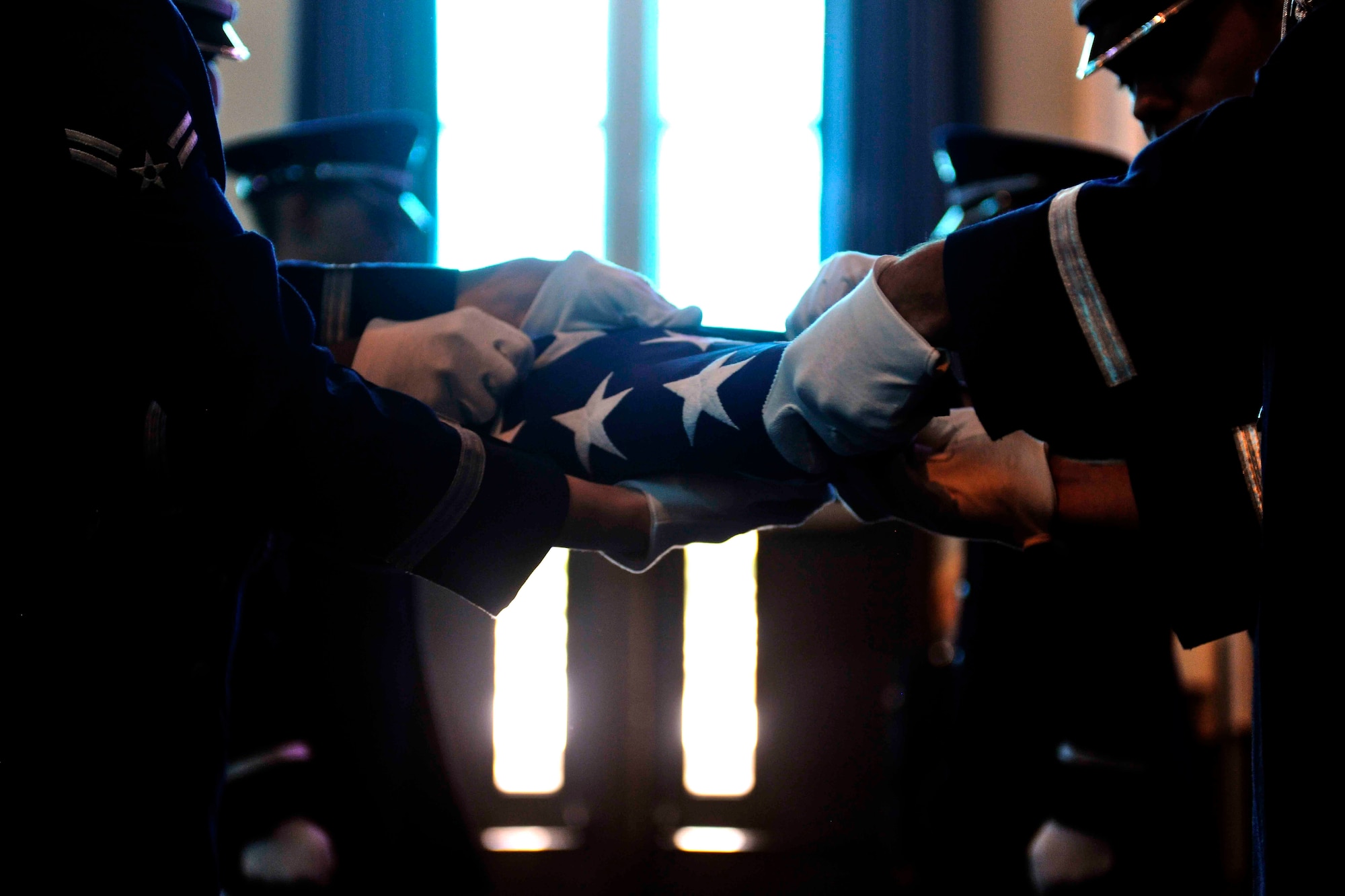 ALTUS AIR FORCE BASE, Okla. – Members of the 97th Air Mobility Wing Honor Guard fold a flag during a memorial service for U.S. Air Force Staff Sgt. Tedd Adair, 97th Logistics Readiness Squadron hazardous material section supervisor, at the base chapel May 19, 2014. More than 150 Airmen and their families filled the base chapel in remembrance of Adair, who passed away May 10 after being diagnosed with cancer. He is survived by his father Jack, mother Deborah, brother Todd, sister Kerri, son Wyatt and daughter Trinity. (U.S. Air Force photo by Senior Airman Jesse Lopez/Released)