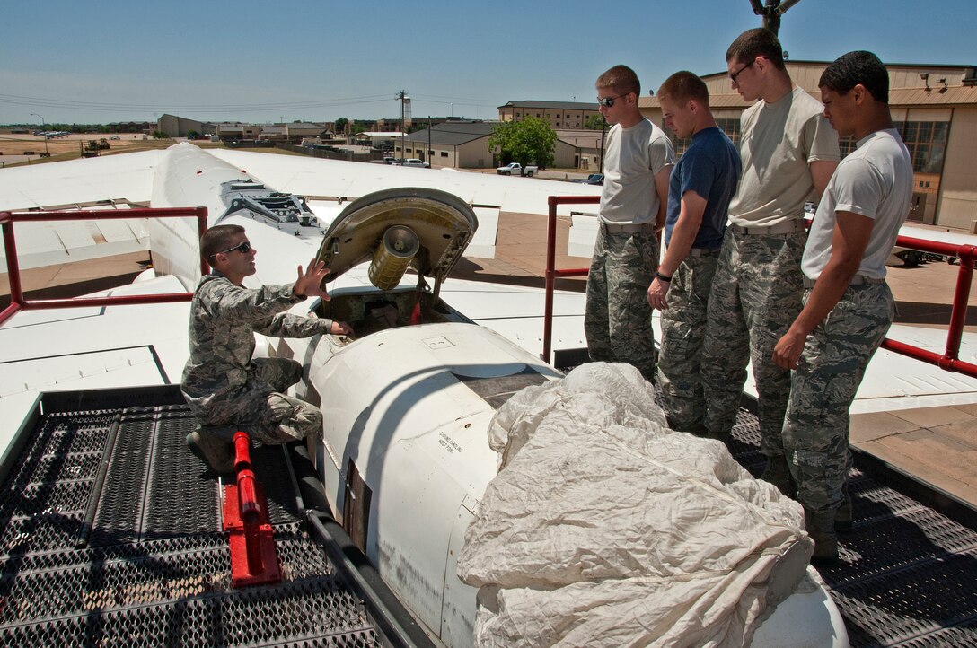 U.S. Air Force Staff Sgt. Shane White is teaching Airman 1st Class Jarrod Hebert, Airman Shane Vandevelde, Christopher Martin and Kelvin Pruitt of the 362nd Training Squadron Crew Chief course, to remove and install a drogue parachute on a B-52 aircraft on May 9, 2014 at Sheppard Air Force Base, Texas. Each time the aircraft lands it deploys the parachute and must be replaced before the aircraft can take off again. (U.S. Air Force photo by Frank Carter/Released)