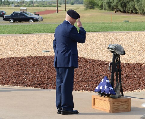 Maj. Met Berisha, 9th Security Forces Squadron commander, salutes a battlefield cross during a National Police Week memorial ceremony at Beale Air Force Base, Calif., May 15, 2014. National Police week is held every May to recognize the service and sacrifice of law enforcement officers.  (U.S. Air Force photo by John Schwab/Released)