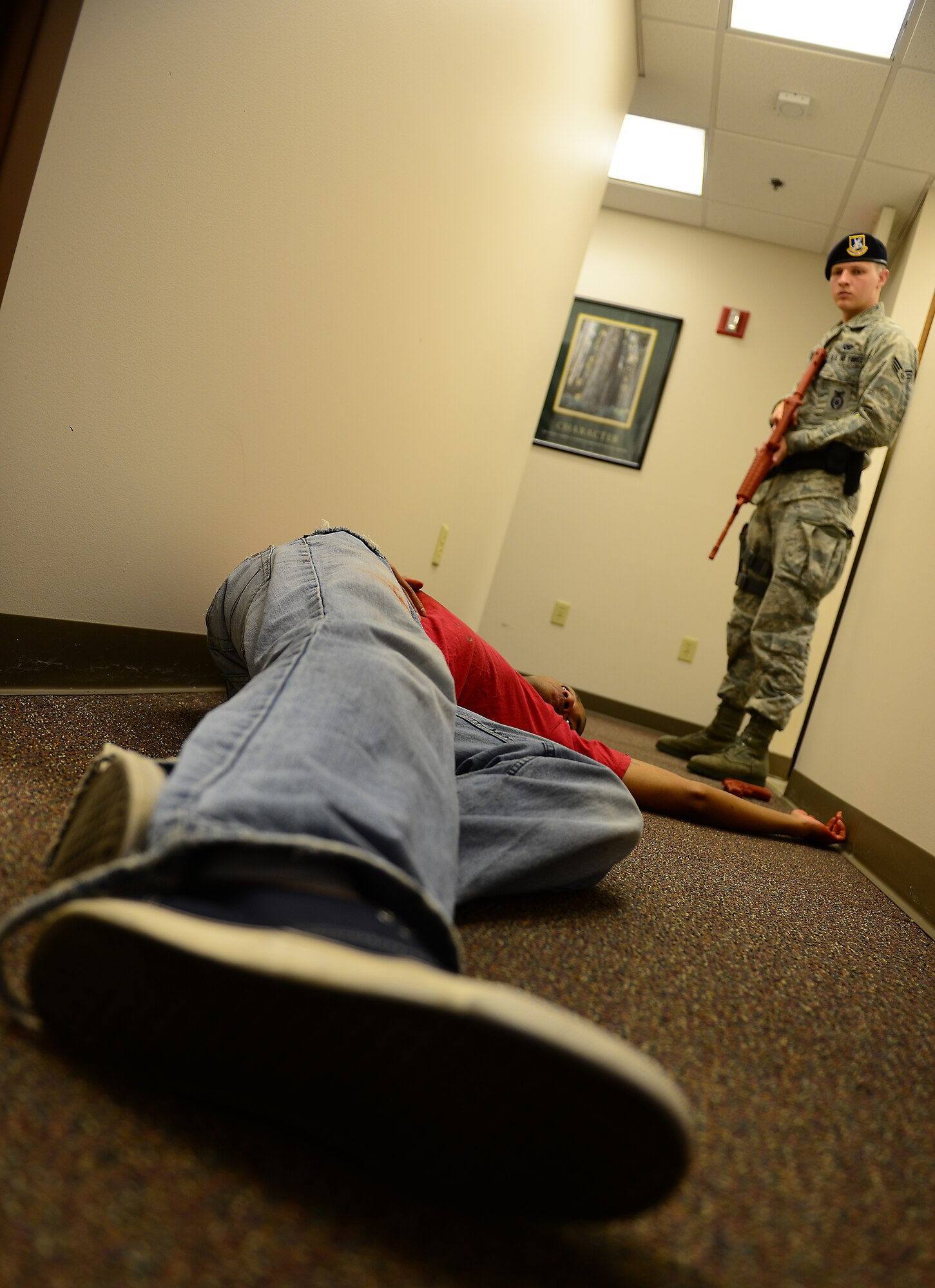 MOODY AIR FORCE BASE, Ga. – An Airman of the 23d Security Forces Squadron stands guard over the body of the active shooter in the base education office during an active shooter exercise at Moody Air Force Base, Ga., May 16, 2014. The exercise enabled the Exercise Evaluator Team (EET) members to gauge the reaction and response times of security forces and medical personnel. (U.S. Air Force photo by Senior Airman Tiffany M. Grigg/Released)
