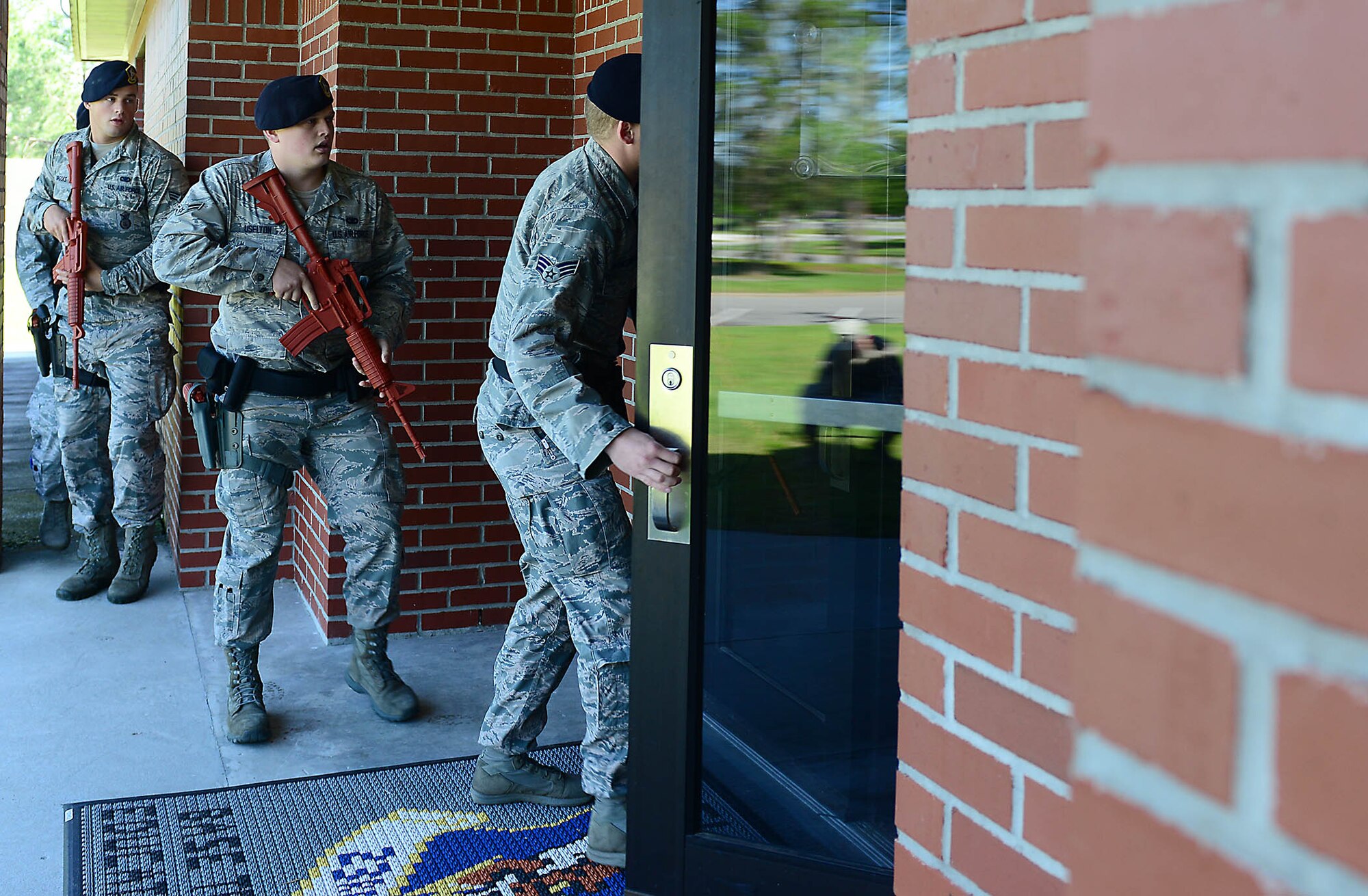 MOODY AIR FORCE BASE, Ga. – Airmen from the 23d Security Forces Squadron enter the base education office in response to an active shooter exercise at Moody Air Force Base, Ga., May 16, 2014. The exercise was implemented to primarily test the reactions and responses of security forces members, medical personnel and firefighters. (U.S. Air Force photo by Senior Airman Tiffany M. Grigg/Released)