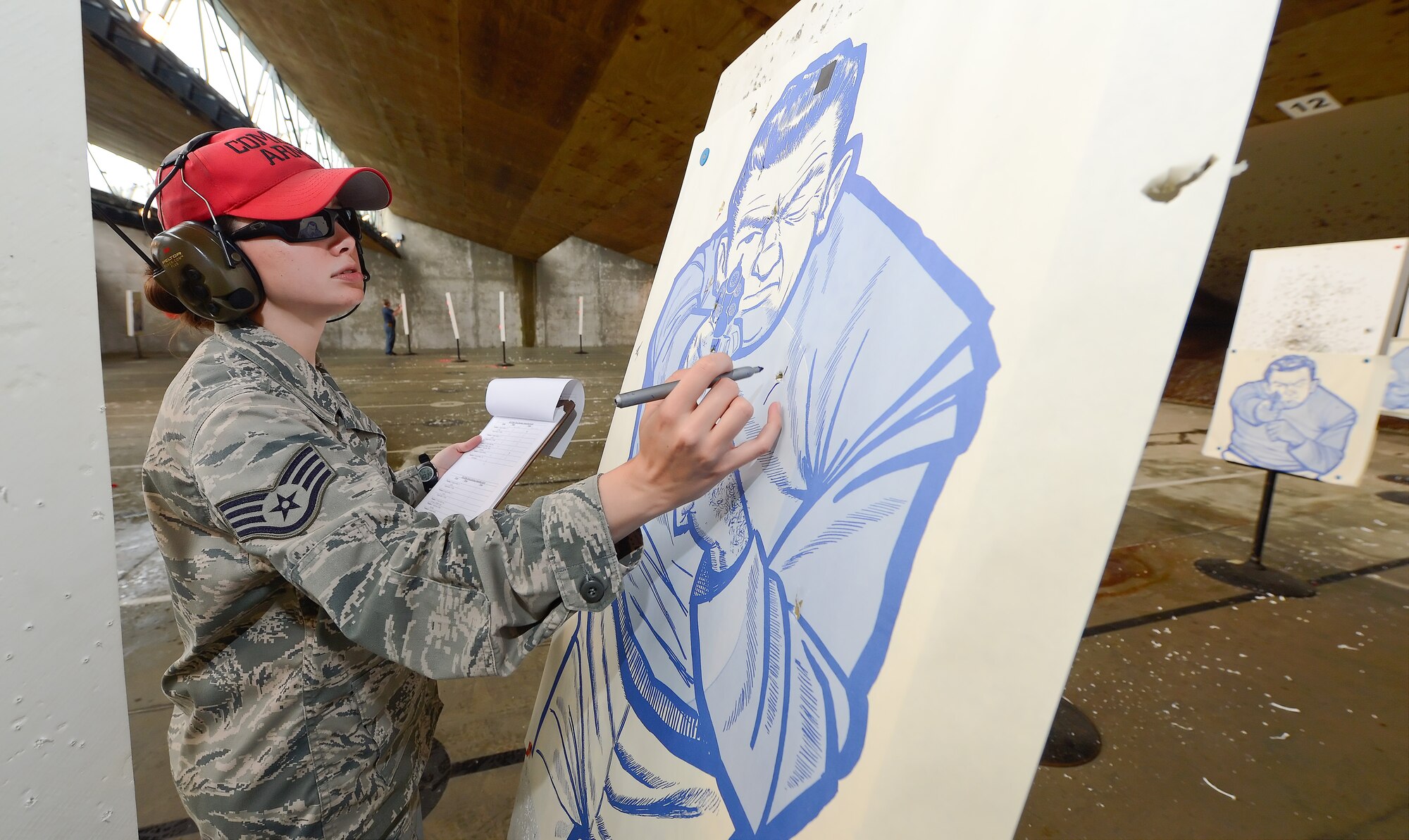 Staff Sgt. Misty Skiles, 436th Security Forces Squadron combat arms instructor, marks-off hits on paper targets while tallying scores during a pistol shooting competition May 15, 2014, at Dover Air Force Base, Del. Skiles served as a combat arms range safety supervisor for a shooting competition held during the 2014 Police Week. (U.S. Air Force photo/Greg L. Davis)