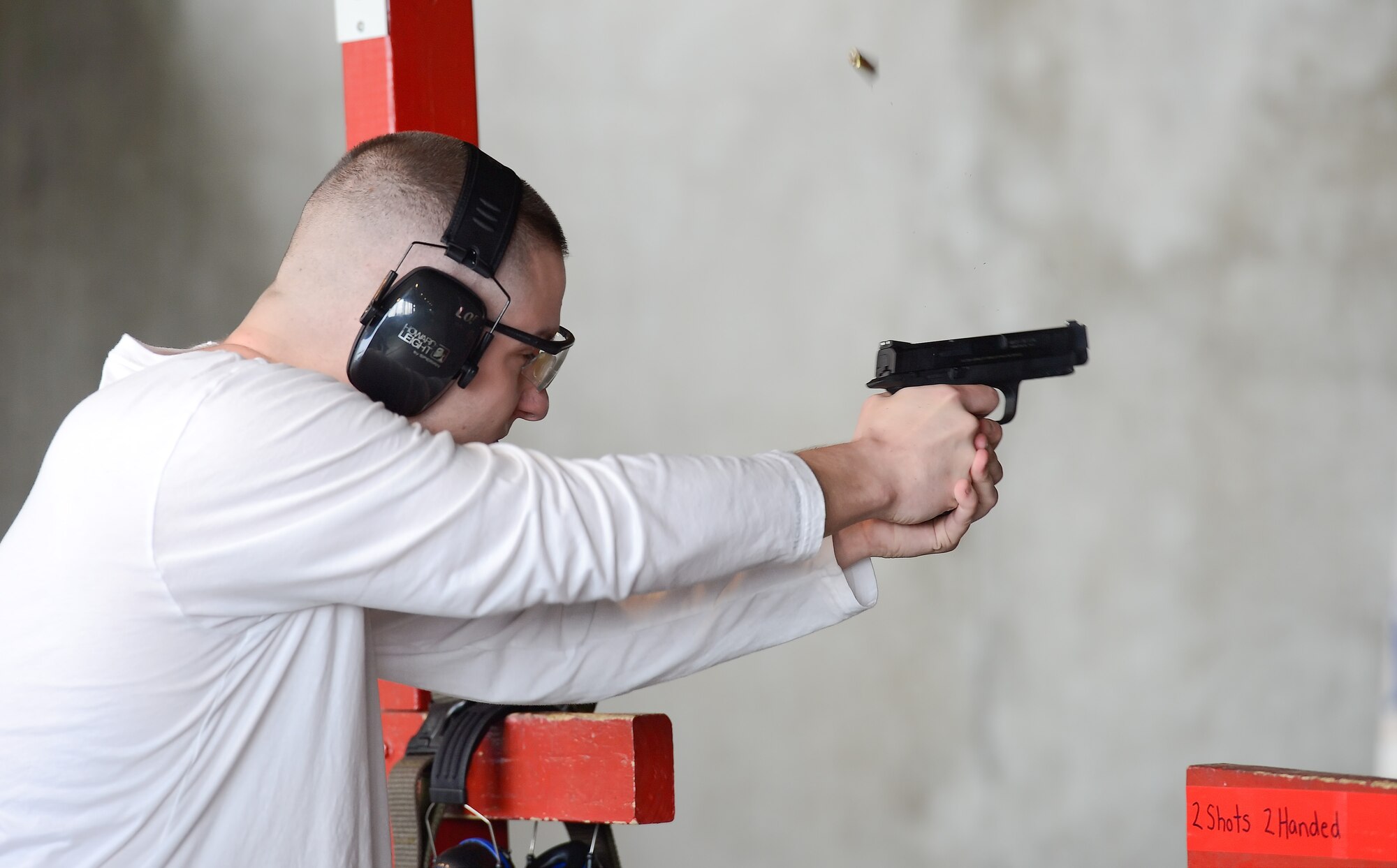 A spent shell is captured in-flight after being ejected from a pistol during a shooting competition hosted by the 436th Security Forces Squadron May 15, 2014, at Dover Air Force Base, Del., during 2014 Police Week. For this portion of the event shooters tried to knock-down sets of bowling pins with just two shots. (U.S. Air Force photo/Greg L. Davis)