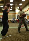 Staff Sgt. Travis Demers, 341st Civil Engineer Squadron heating ventilation and air conditioning technician, shoots a basketball during Wing Sports Smackdown at the Grizzly Bend on May 16. Master Sgt. Britt Bare, 341st CES member and WSS volunteer, assists. (U.S. Air Force photo/Senior Airman Katrina Heikkinen)