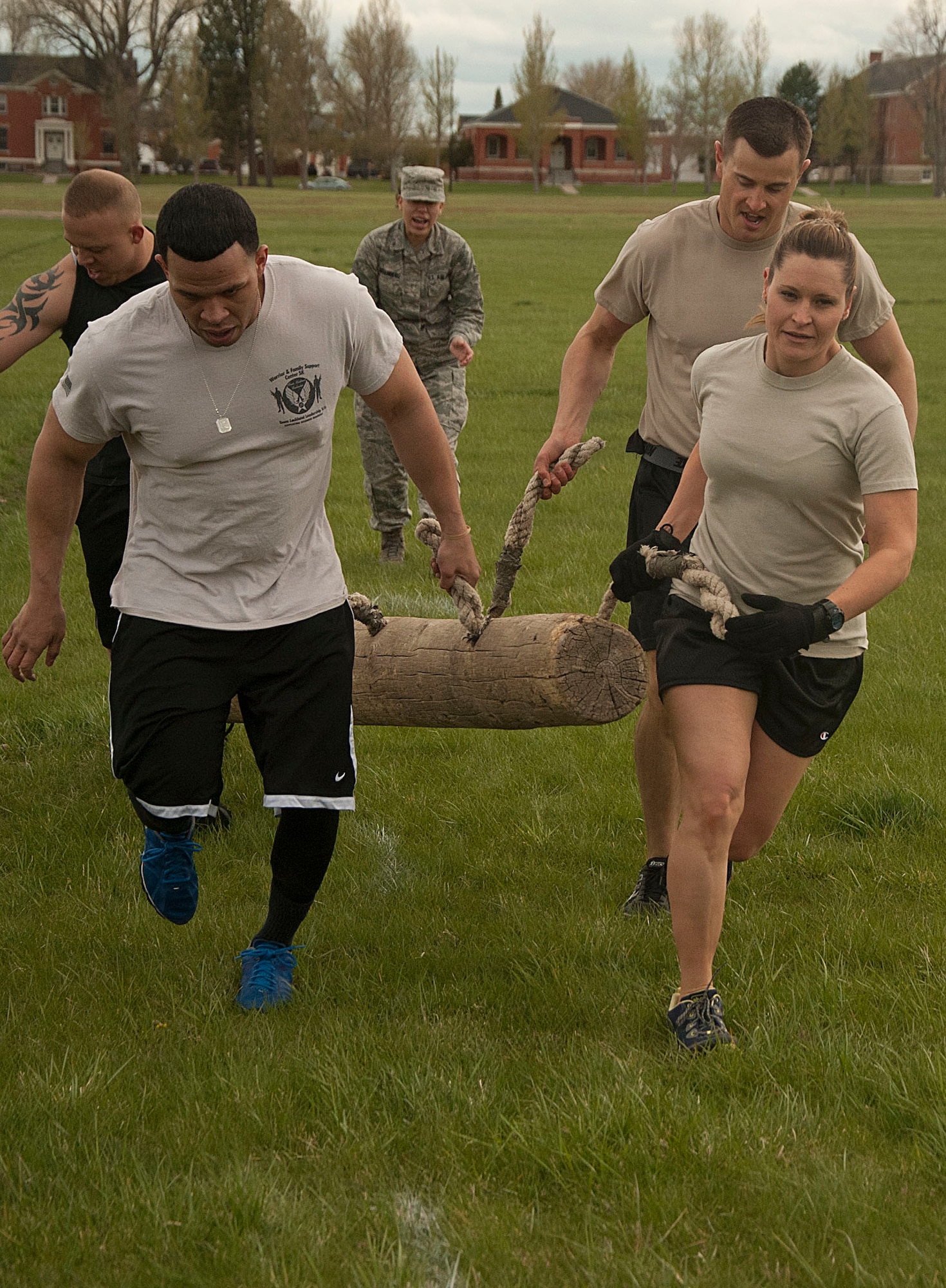140516-F-GZ967-064 Tech Sgt. Megan Thompson, Staff Sgts. Lou Robinson and Joshua Hansen, and Airman 1st Class Edgar Zarraga, 90th Security Forces Group Tactical Response Force, carry a log during the team torture event May 16. Each team had to carry the log 25 yards, place it back on the ground, turn around and carry the log back to the starting line. (U.S. Air Force photo by Airman 1st Class Brandon Valle)