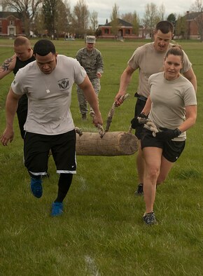 140516-F-GZ967-064 Tech Sgt. Megan Thompson, Staff Sgts. Lou Robinson and Joshua Hansen, and Airman 1st Class Edgar Zarraga, 90th Security Forces Group Tactical Response Force, carry a log during the team torture event May 16. Each team had to carry the log 25 yards, place it back on the ground, turn around and carry the log back to the starting line. (U.S. Air Force photo by Airman 1st Class Brandon Valle)