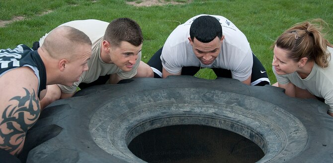 140516-F-GZ967-037 Tech Sgt. Megan Thompson, Staff Sgts. Lou Robinson and Joshua Hansen, and Airman 1st Class Edgar Zarraga, 90th Security Forces Group Tactical Response Force, prepare to lift a 500-pound tire during the team torture event May 16. The TRF team took first place by just over 40 seconds. (U.S. Air Force photo by Airman 1st Class Brandon Valle)