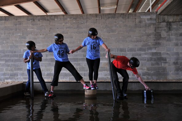 Key spouses from the 42nd Air Base Wing work together to complete a Project X Leadership Reaction Course exercise, May, 19, 2014, here. They went through the course to gain new insights and establish unique ways to solve problems that could be used to help Airmen. (U.S. Air Force photo by Staff Sgt. Natasha Stannard)