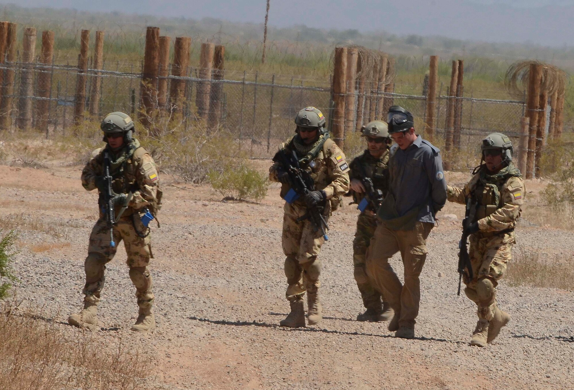 Members of a Multinational Search and Rescue Team  capture an opposition force member during a training mission in Exercise ANGEL THUNDER on May 16, 2014 at the Florence Military Reservation, Ariz. ANGEL THUNDER 2014 is the largest and most realistic joint service, multinational, interagency combat search and rescue exercise designed to provide training for personnel recovery assets using a variety of scenarios to simulate deployment conditions and contingencies. Personnel recovery forces will train through the full spectrum of personnel recovery capabilities with ground recovery personnel, air assets, and interagency teams. (U.S. Air Force photo by Staff Sgt. Adam Grant/Released)