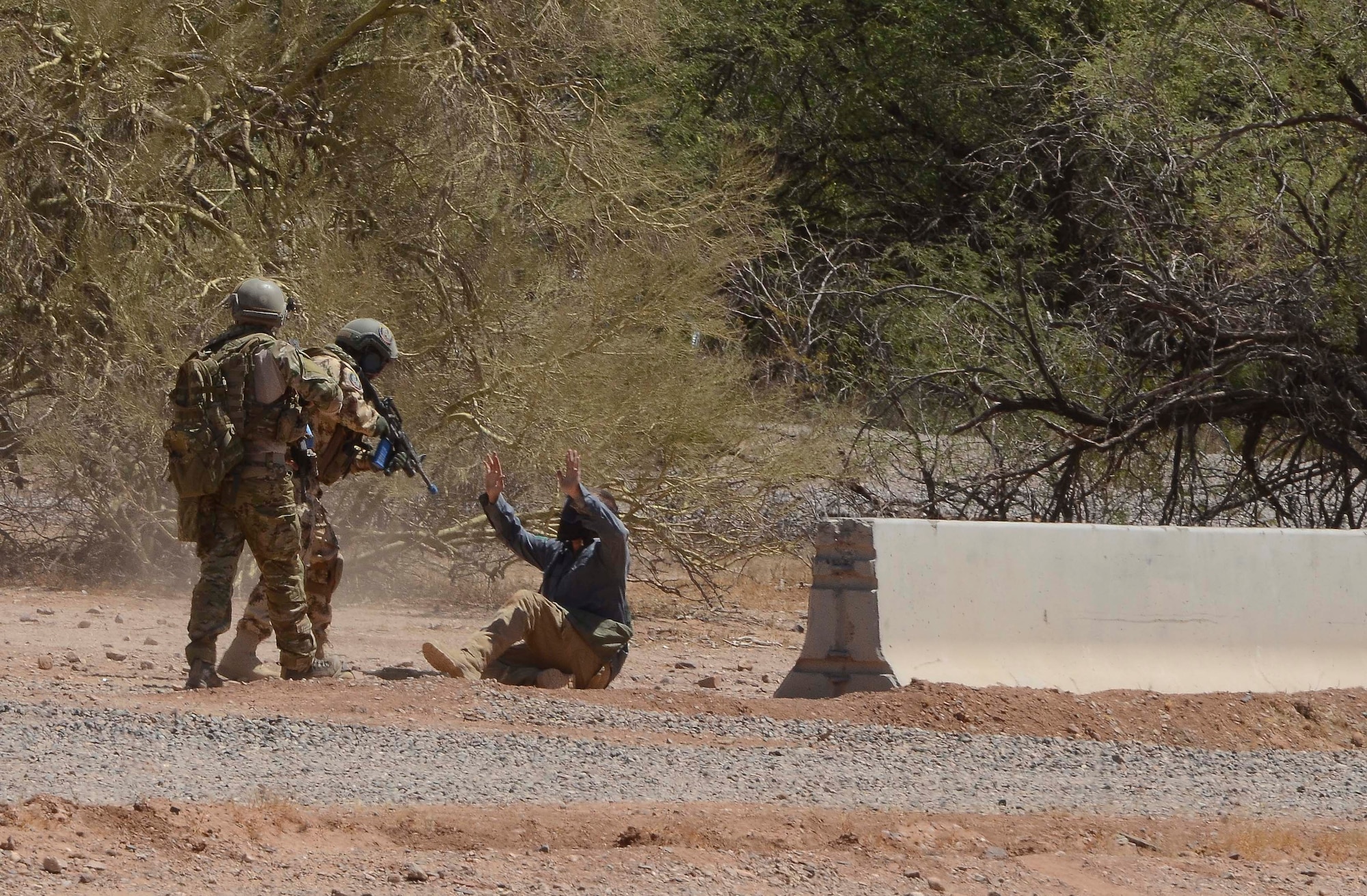 A Combat Search and Rescue team capture an opposition force member at training site during a training mission in Exercise ANGEL THUNDER on May 16, 2014 at the Florence Military Reservation, Ariz. ANGEL THUNDER 2014 is the largest and most realistic joint service, multinational, interagency combat search and rescue exercise designed to provide training for personnel recovery assets using a variety of scenarios to simulate deployment conditions and contingencies. Personnel recovery forces will train through the full spectrum of personnel recovery capabilities with ground recovery personnel, air assets, and interagency teams. (U.S. Air Force photo by Staff Sgt. Adam Grant/Released)