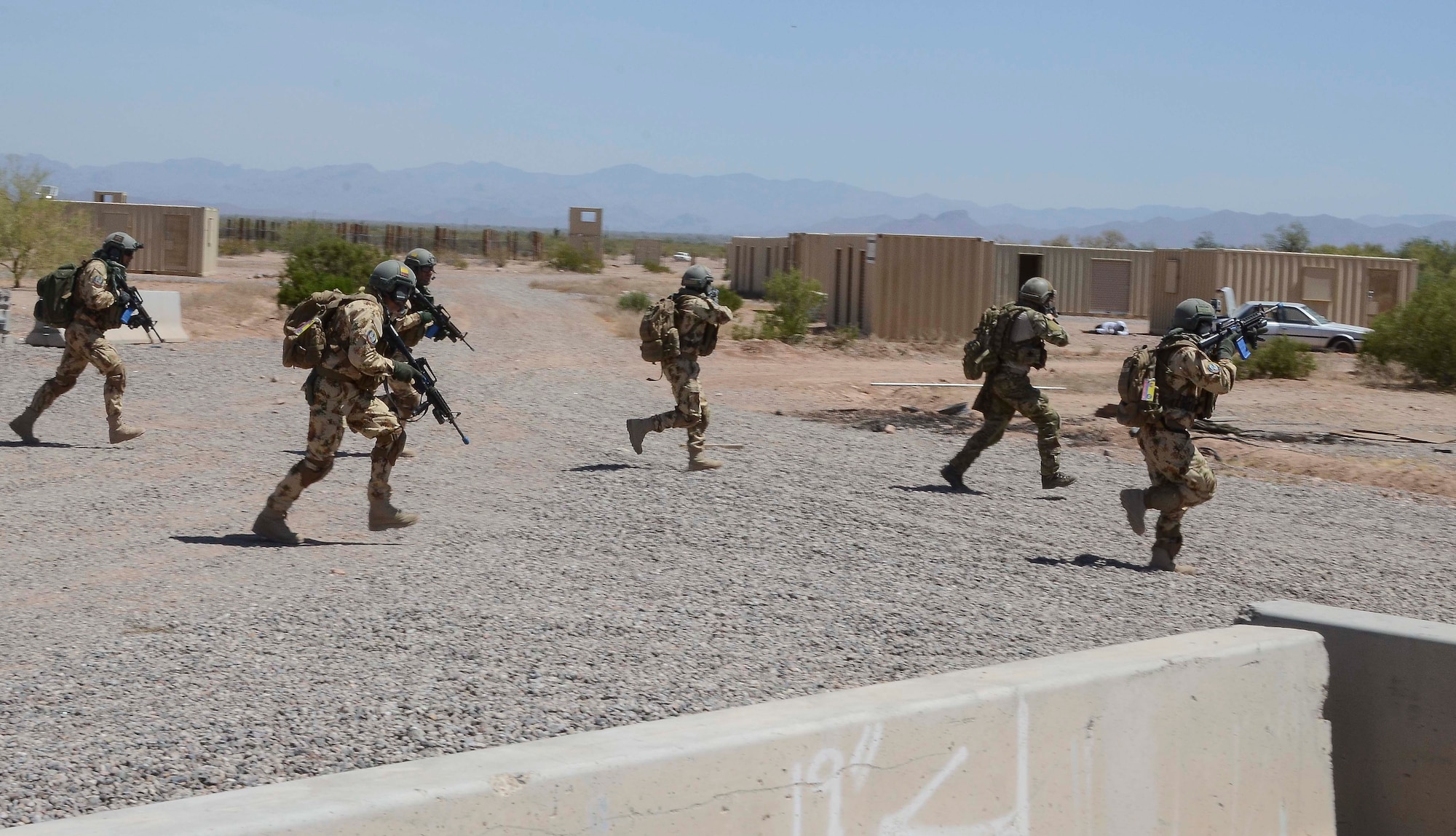Members  of a Multinational Combat Search and Rescue team sprint to a forward location at  training site during a training mission in Exercise ANGEL THUNDER on May 16, 2014 at the Florence Military Reservation, Ariz. ANGEL THUNDER 2014 is the largest and most realistic joint service, multinational, interagency combat search and rescue exercise designed to provide training for personnel recovery assets using a variety of scenarios to simulate deployment conditions and contingencies. Personnel recovery forces will train through the full spectrum of personnel recovery capabilities with ground recovery personnel, air assets, and interagency teams. (U.S. Air Force photo by Staff Sgt. Adam Grant/Released)