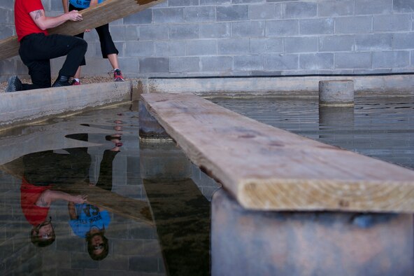 Nick Merkle, the 42nd Comptroller Squadron commander’s husband, and Pam Borgert, the 42nd Mission Support Group commander’s wife, lay out wooden planks to walk across during a Project X Leadership Reaction Course exercise, May 19, 2014, here. Merkle and Borgert went through the course to strengthen bonds with fellow 42nd Air Base Wing key spouses. The course is setup to physically and mentally challenge people, as well as promote team work. (U.S. Air Force photo by Staff Sgt. Natasha Stannard)