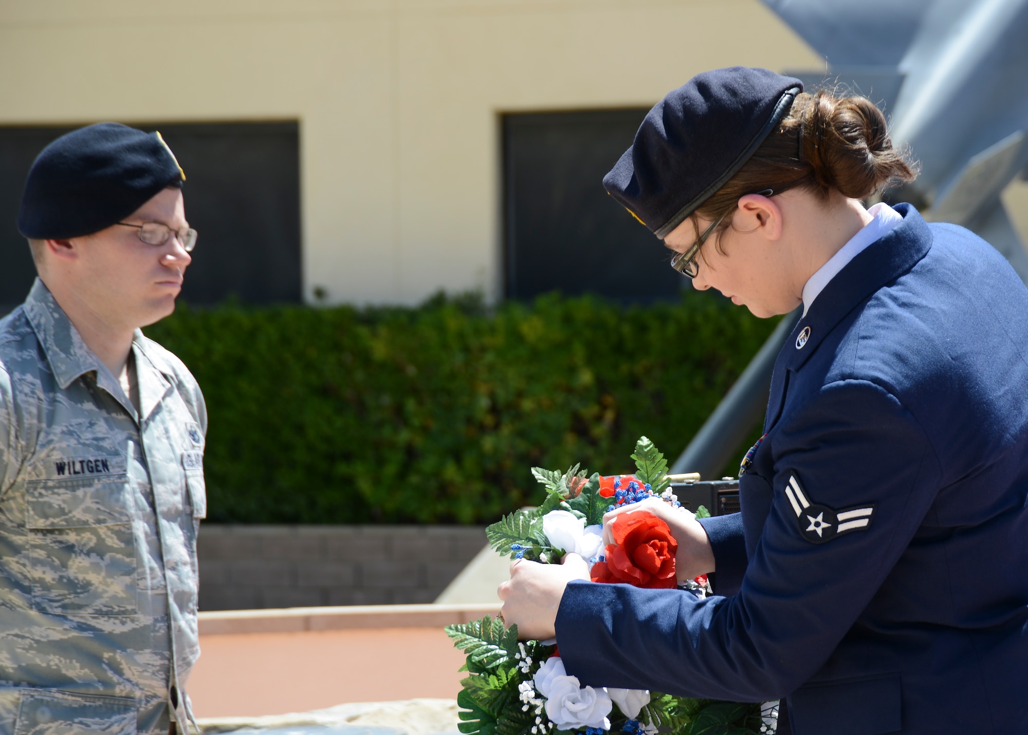 Airman 1st Class Veronica Esparza, 412th Security Forces Squadron, places her carnation in the wreath used to recognize the purity of an officer’s intentions to keep the nation's citizens free and safe. The additional carnation represents the members of her agency that have died. (U.S. Air Force Photo by Rebecca Amber)