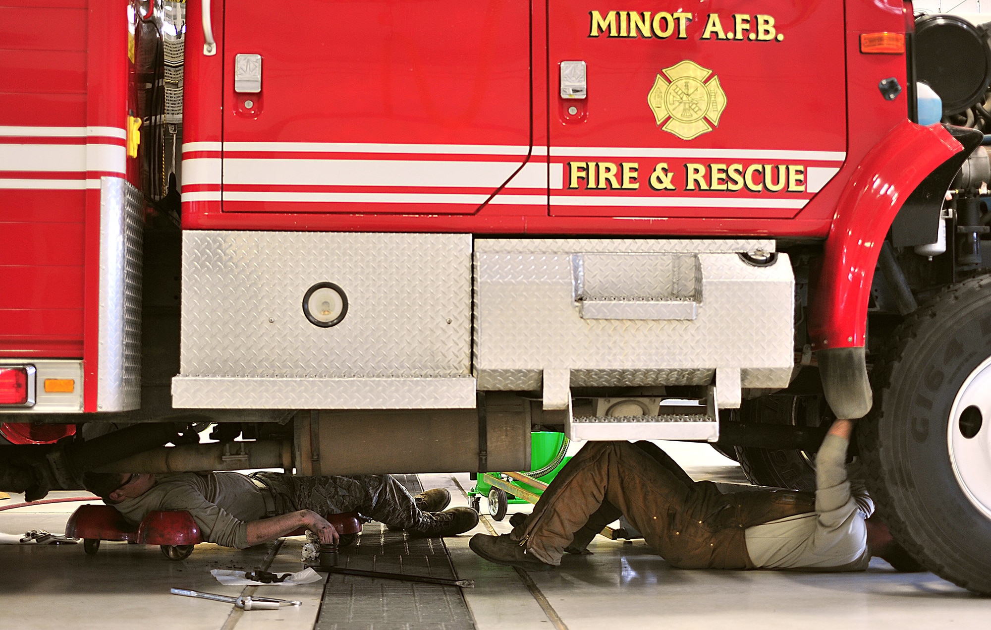 Airman 1st Class Jeffery Kesler and Senior Airman Brett Randolph, 5th Logistics Readiness Squadron Fire Truck Maintenance Team members, work under a P-30 utility fire truck at Minot Air Force Base, N.D., May 13. The team determines serviceability, overall condition of the trucks and need for repair by diagnostic, visual and audio examinations. (U.S. Air Force photo/Senior Airman Kristoffer Kaubisch)
