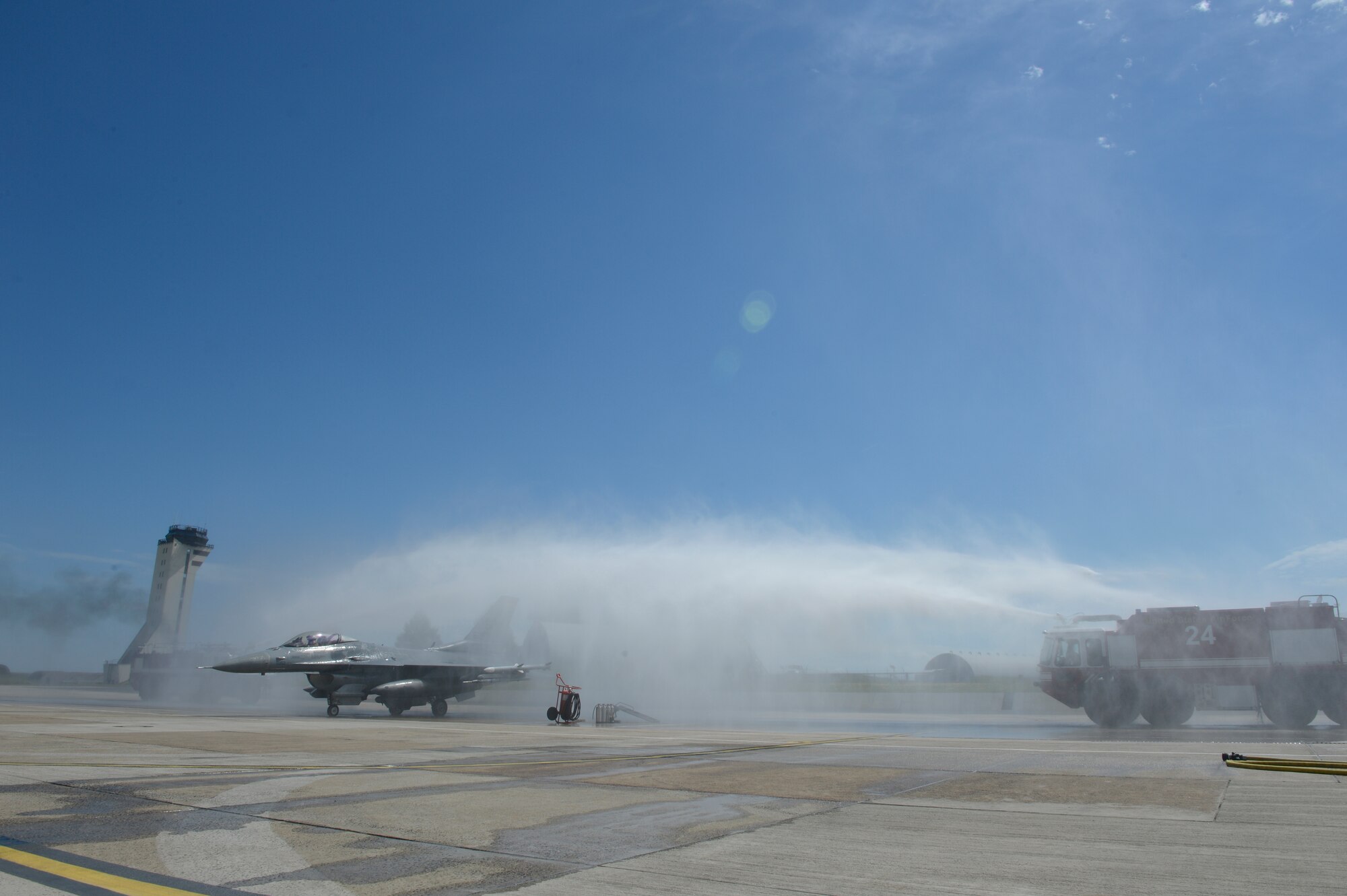 U.S. Air Force Col. David Julazadeh, 52nd Fighter Wing commander, taxis a U.S. Air Force F-16 Fighting Falcon fighter aircraft beneath two streams of water after landing, May, 20, 2014, at Spangdahlem Air Base, Germany.  The 52nd Civil Engineer Squadron provided the two fire trucks in celebration of Julazadeh’s final flight. (U.S. Air Force photo by Staff Sgt. Christopher Ruano/Released)