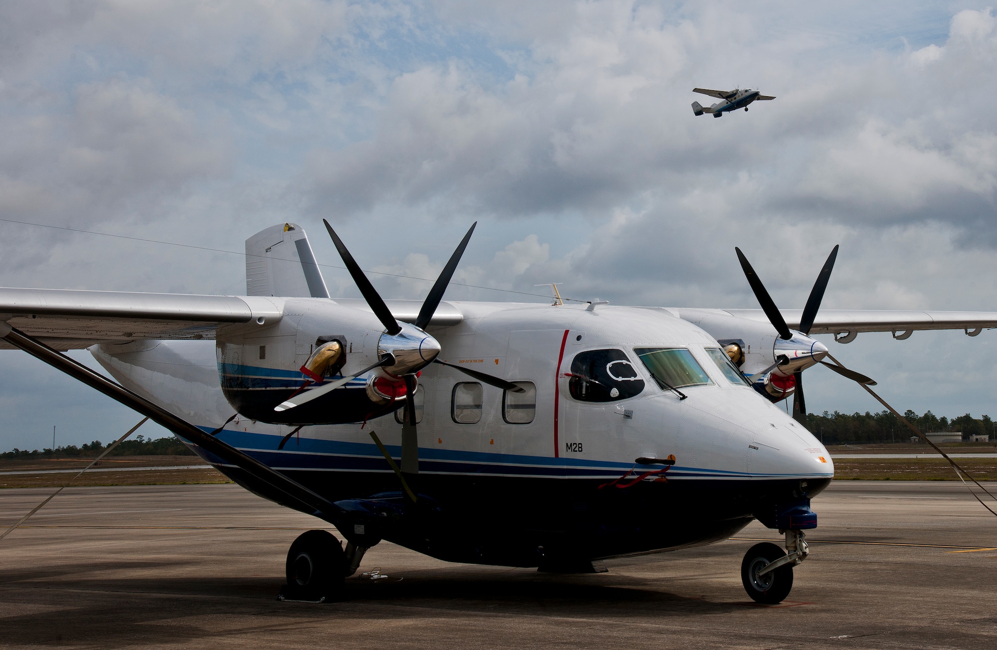 A C-145 Skytruck waits for its next mission while another Skytruck lifts off from the runway at Duke Field Fla. The Aviation Foreign Internal Defense and Skytruck mission is a joint active-duty and reserve Air Force Special Operations Command mission.  (U.S. Air Force photo/Tech. Sgt. Samuel King Jr.)