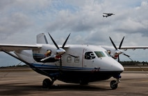 A C-145 Skytruck waits for its next mission while another Skytruck lifts off from the runway at Duke Field Fla. The Aviation Foreign Internal Defense and Skytruck mission is a joint active-duty and reserve Air Force Special Operations Command mission.  (U.S. Air Force photo/Tech. Sgt. Samuel King Jr.)