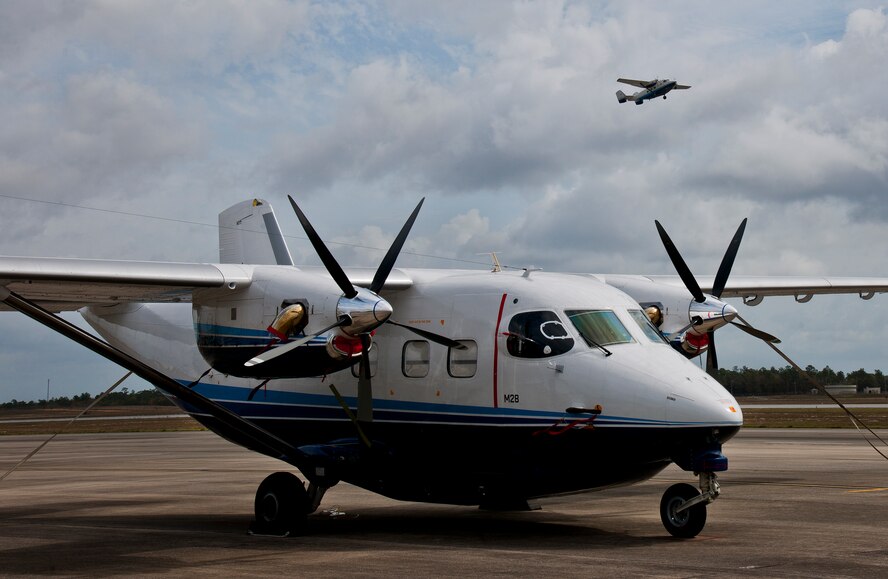 A C-145 Skytruck waits for its next mission while another Skytruck lifts off from the runway at Duke Field Fla. The Aviation Foreign Internal Defense and Skytruck mission is a joint active-duty and reserve Air Force Special Operations Command mission.  (U.S. Air Force photo/Tech. Sgt. Samuel King Jr.)