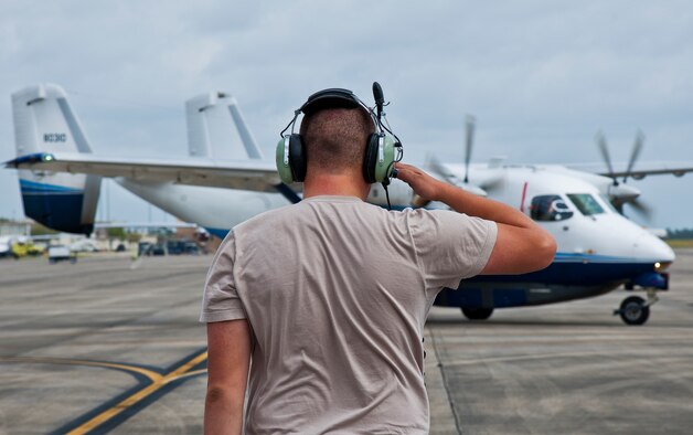 Senior Airman Matthew Johnson, a 592nd Special Operations Maintenance Squadron maintainer, salutes as a C-145 Skytruck taxies out for a sortie at Duke Field, Fla.  The Aviation Foreign Internal Defense and Skytruck mission is a joint active-duty and reserve Air Force Special Operations Command mission.  (U.S. Air Force photo/Tech. Sgt. Samuel King Jr.)