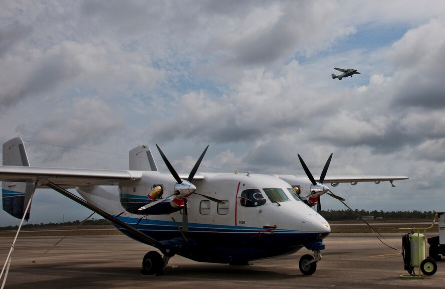 A C-145 Skytruck waits for its next mission while another Skytruck lifts off from the runway at Duke Field Fla. The Aviation Foreign Internal Defense and Skytruck mission is a joint active-duty and reserve Air Force Special Operations Command mission.  (U.S. Air Force photo/Tech. Sgt. Samuel King Jr.)