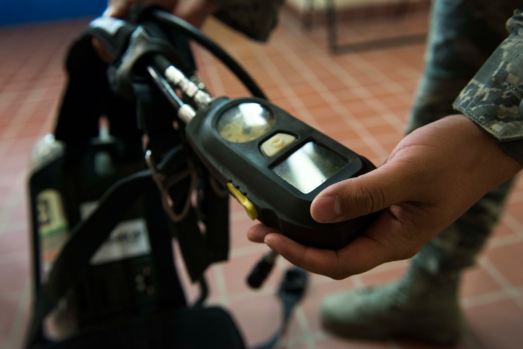 Airman 1st Class Elihar Esparraguerra, 5th Bomb Wing Medical Operations Squadron bioenvironmental engineering technician, inspects his air tank before connecting it to his gas mask during an annual equipment check at Minot Air Force Base, N.D., May 8, 2014. Bioenvironmental is required to recertify on their protective equipment and gear once a year. (U.S. Air Force photo/Airman 1st Class Lauren Pitts)  